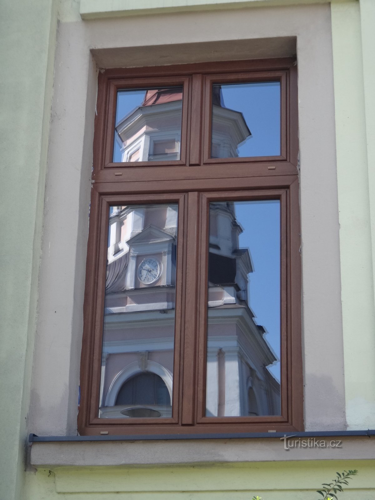 le reflet de l'église dans les fenêtres de la mairie