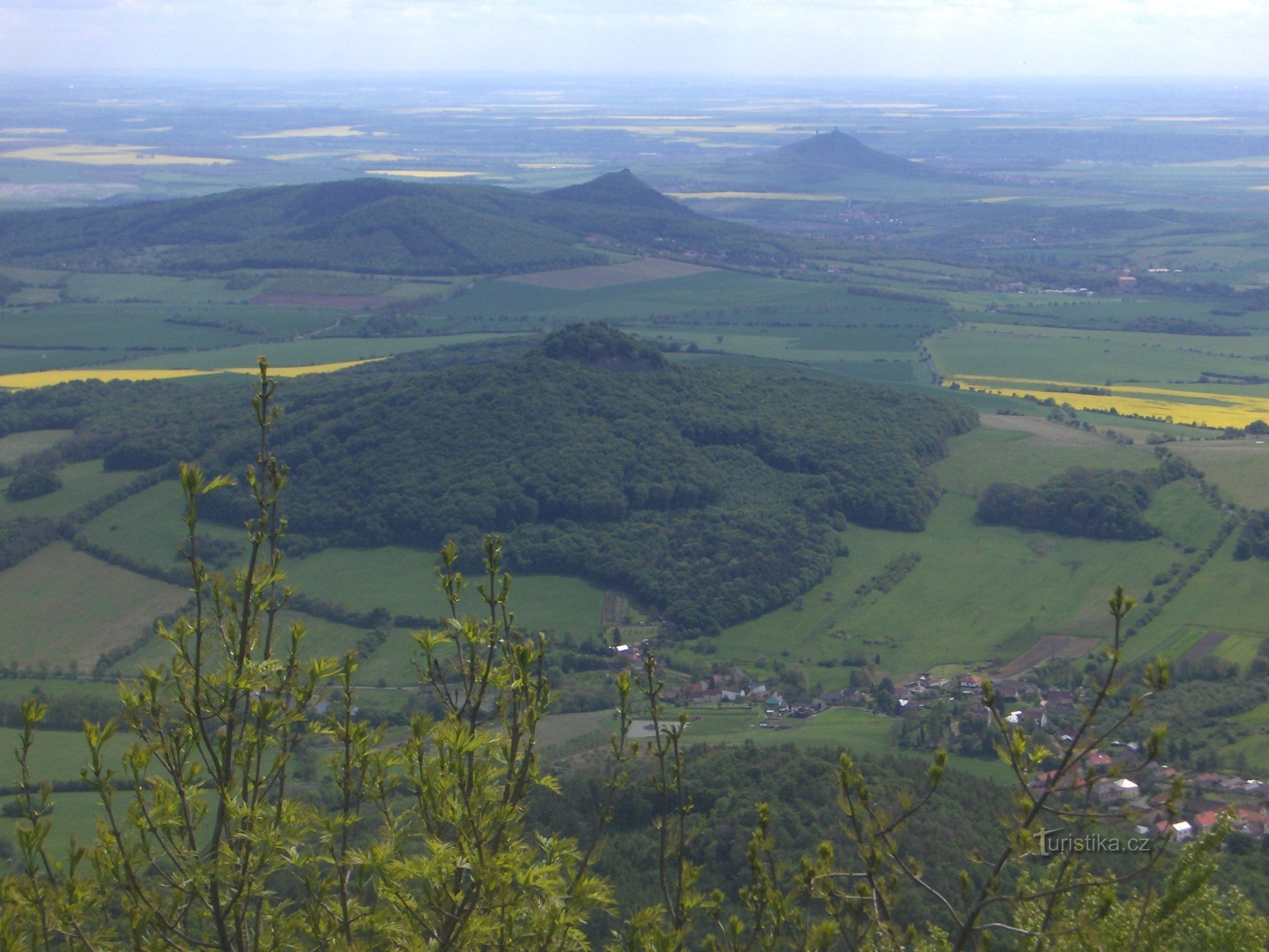 Ostrý z Milešovki, w tle Košťálov i Hazmburk