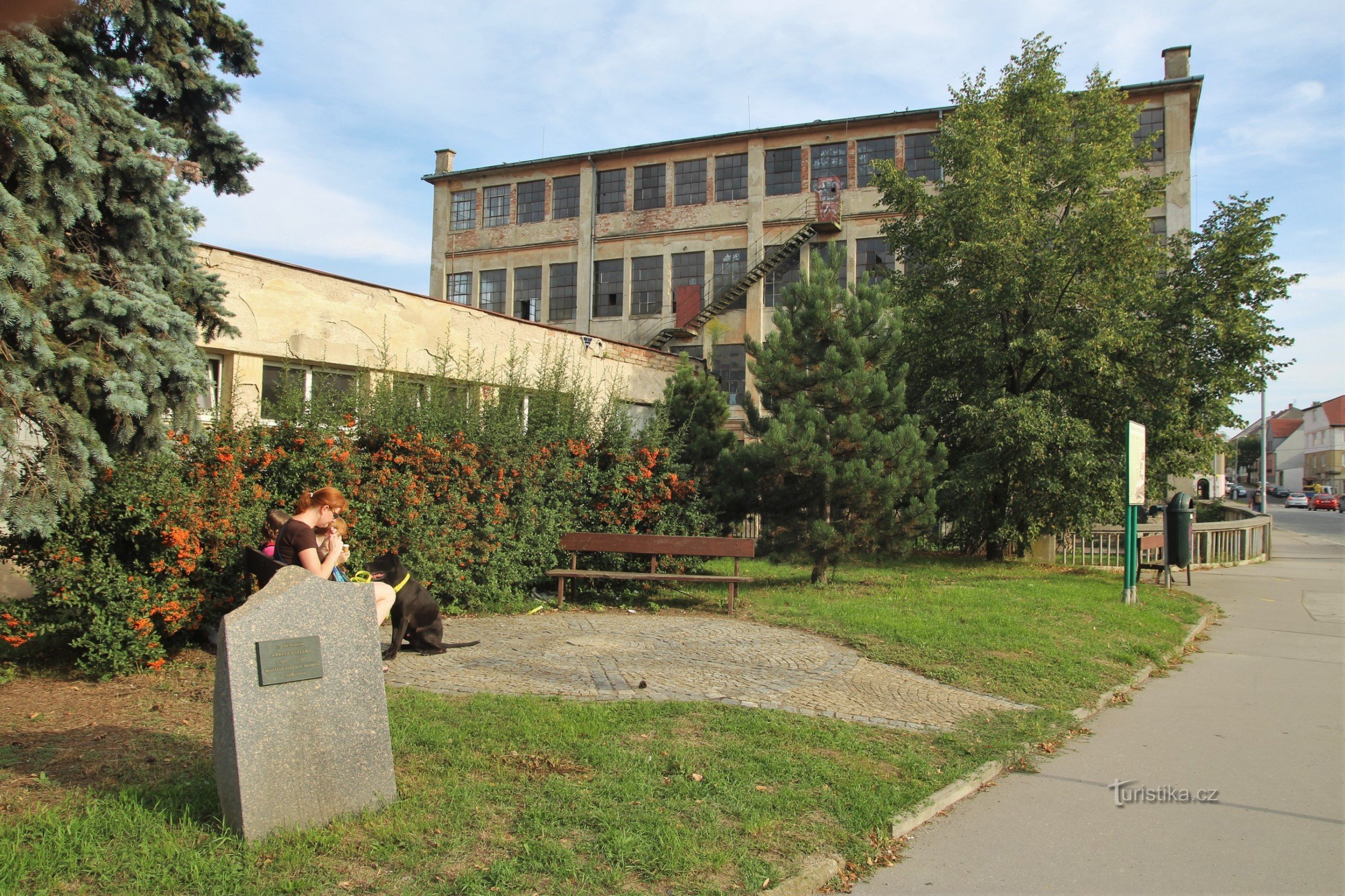 Essler Adolf emlékműve, a háttérben az Essler-gyár épülete