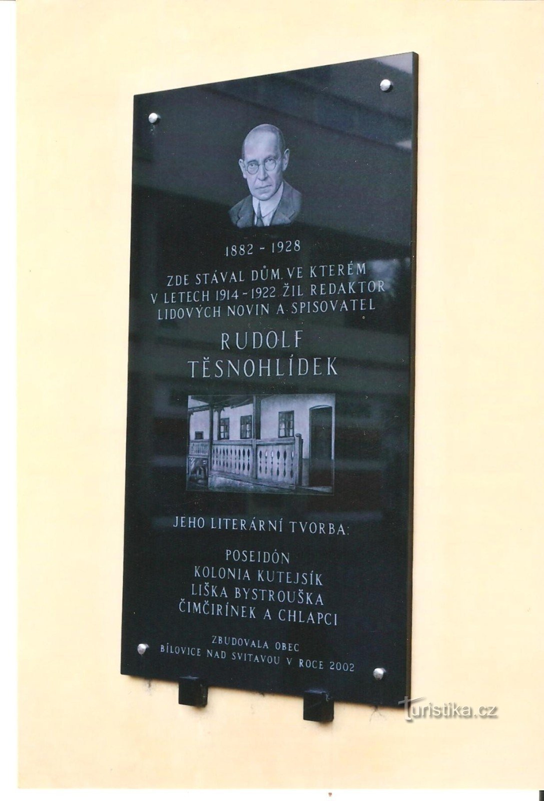 Placa comemorativa de Rudolf Tésnohlídek na parede da casa junto ao estacionamento