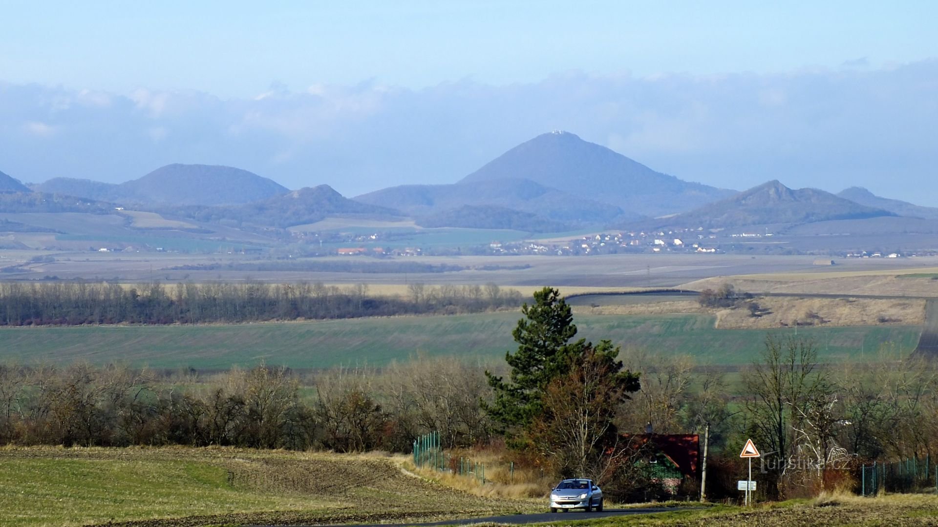 Panorama Českého středohoří s Milešovkou od hřbitova v Levousích