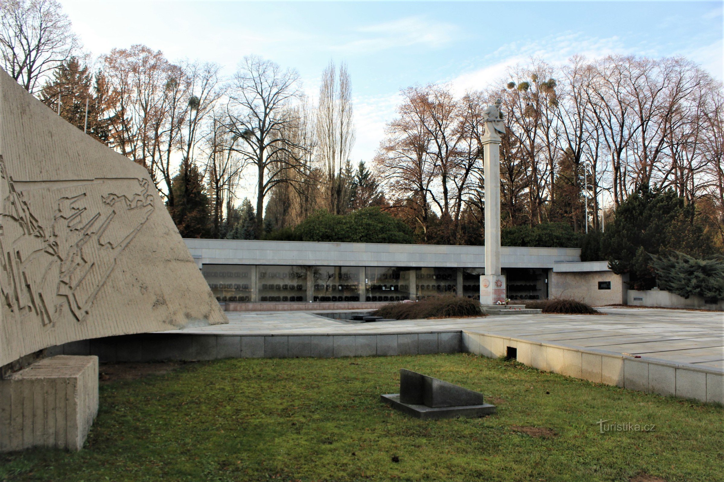 A memorial site of a military cemetery with a statue of a soldier