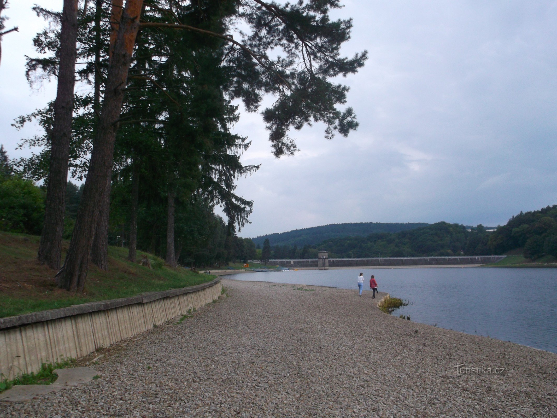 stranden är skild från gräsmarken av en mur