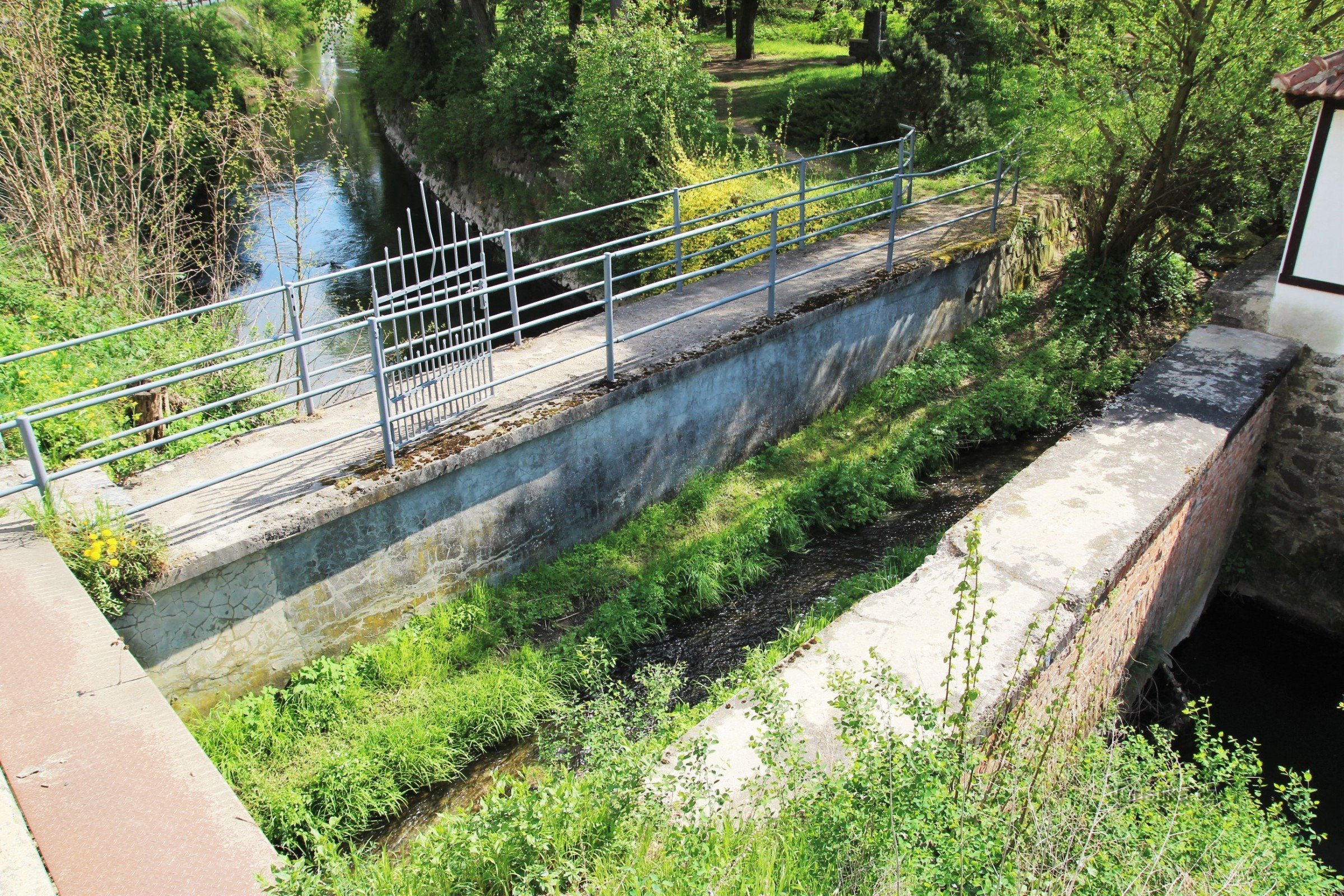 The Časnýř stream flows along the aqueduct, below it is a water drive leading from the mill