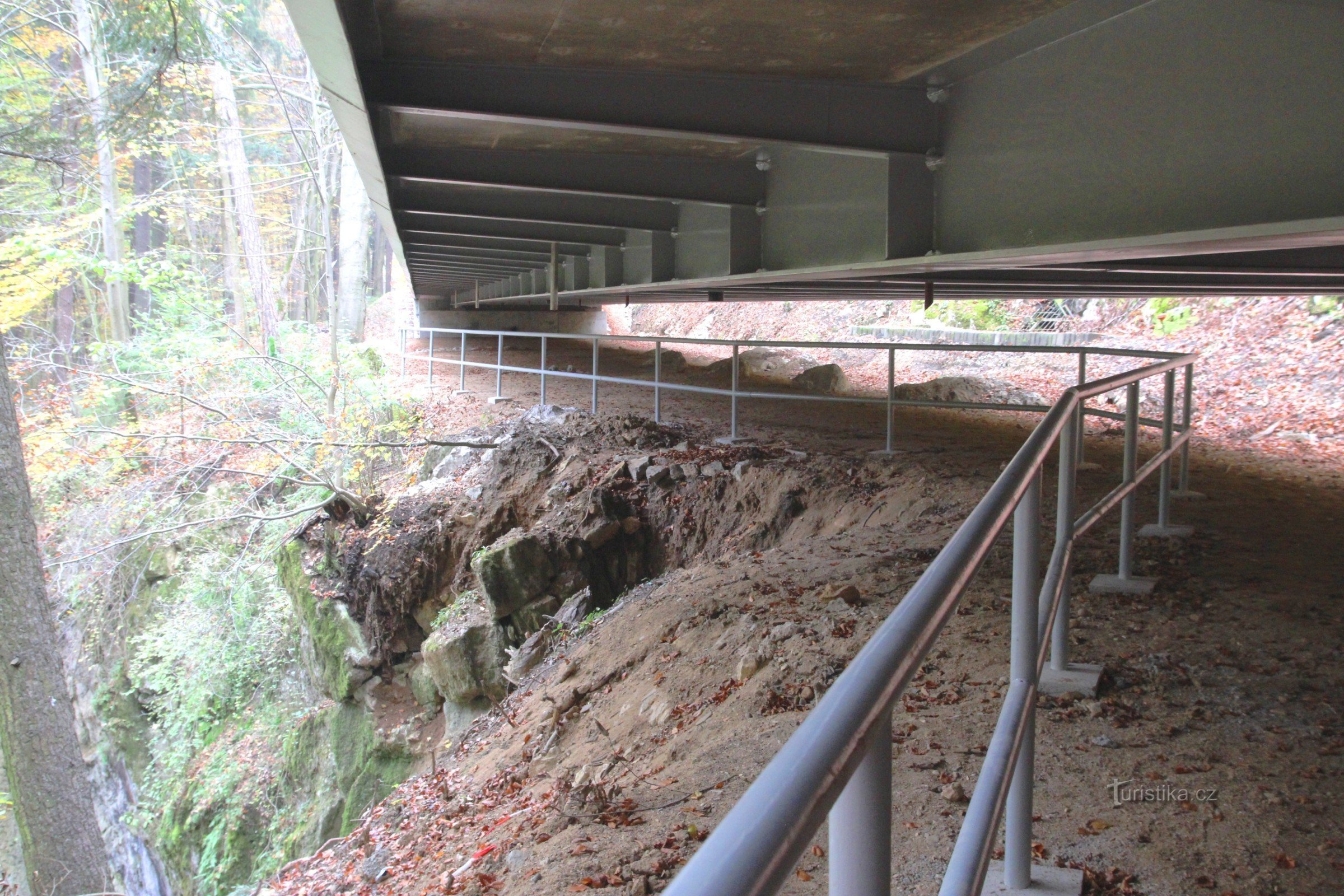 Sob a ponte há uma grade de segurança na borda das rochas, a distância sob a ponte é de cerca de 1,5 m