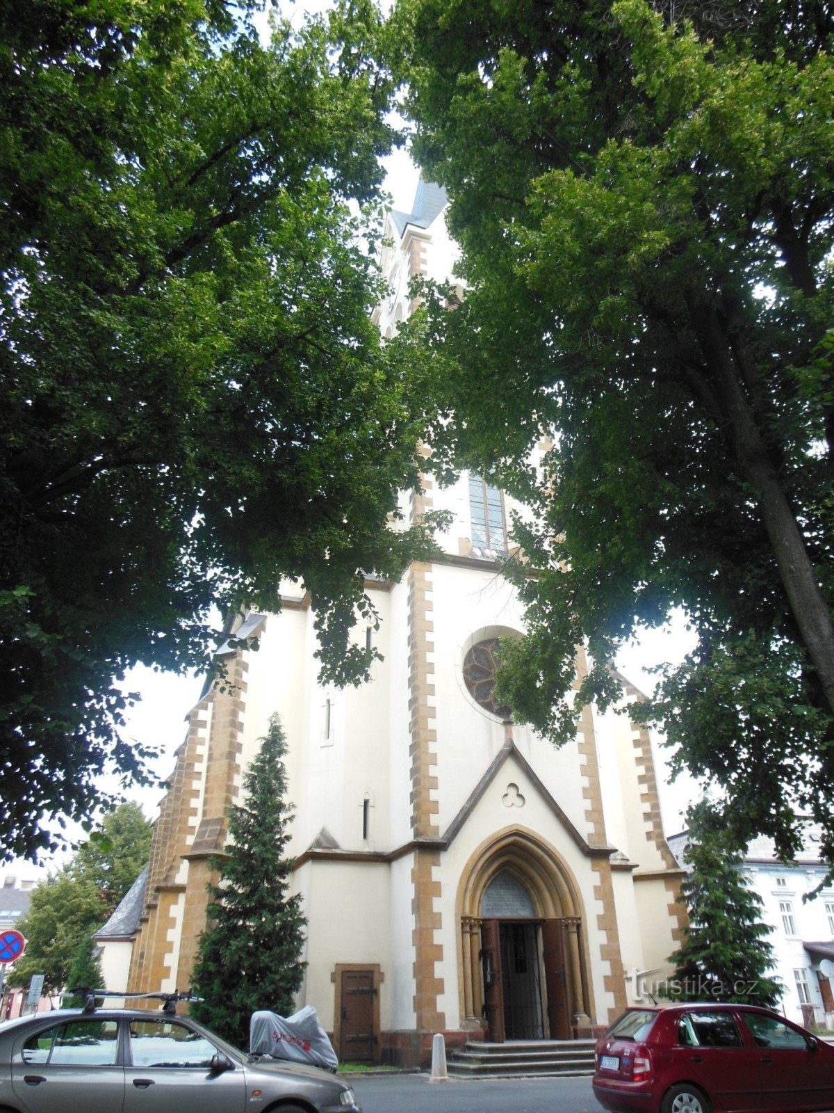 vista de la iglesia a través de los tilos de Lipový náměstí