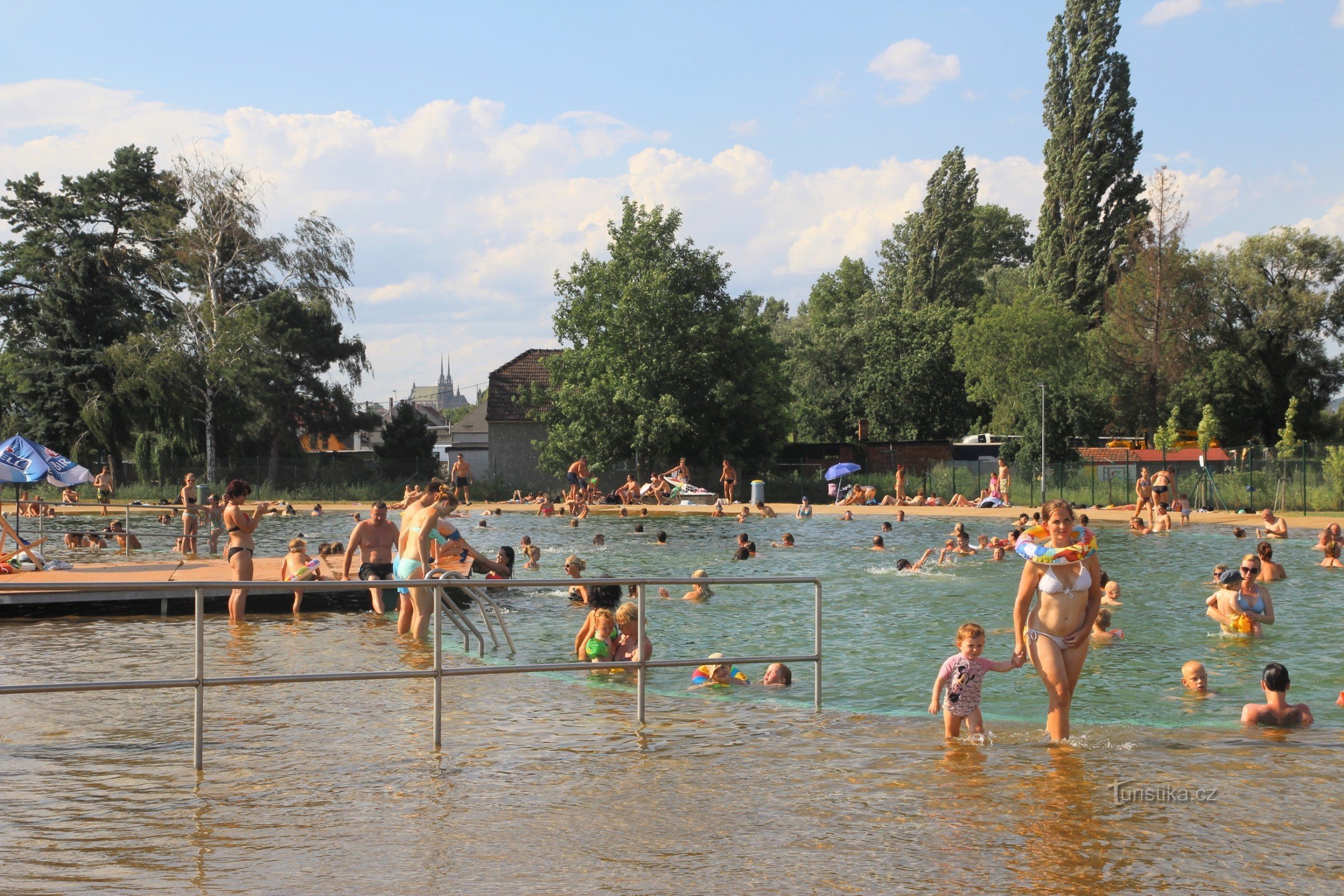 Udsigt over swimmingpoolområdet med Brno-katedralens tårn i baggrunden