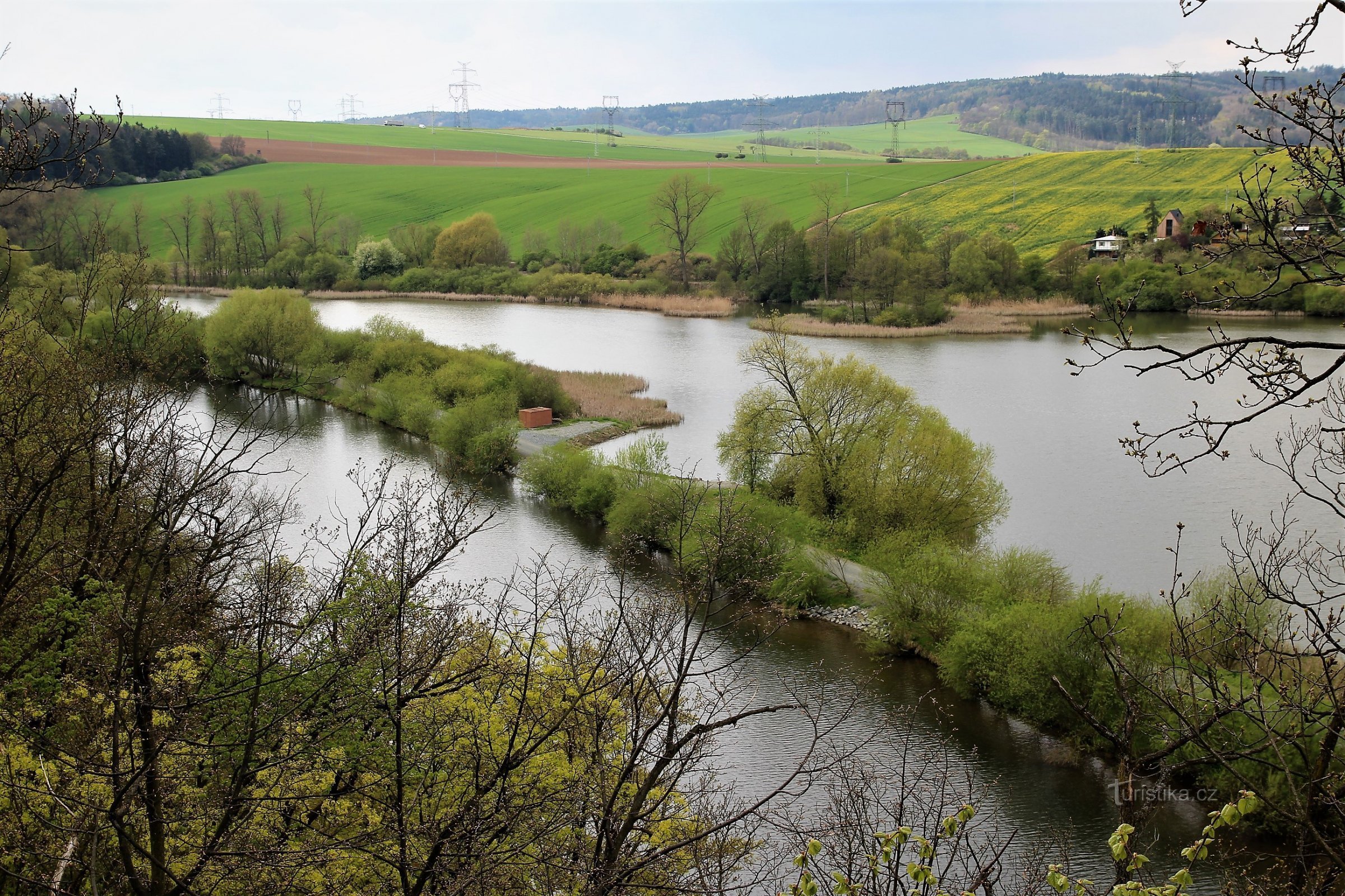 Widok na bagno z punktu widokowego na żółtym znaczniku, na pierwszym planie koniec tamy na rzece Svratce