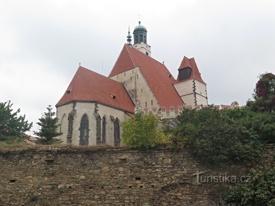 pogled na cerkev skozi mestno obzidje