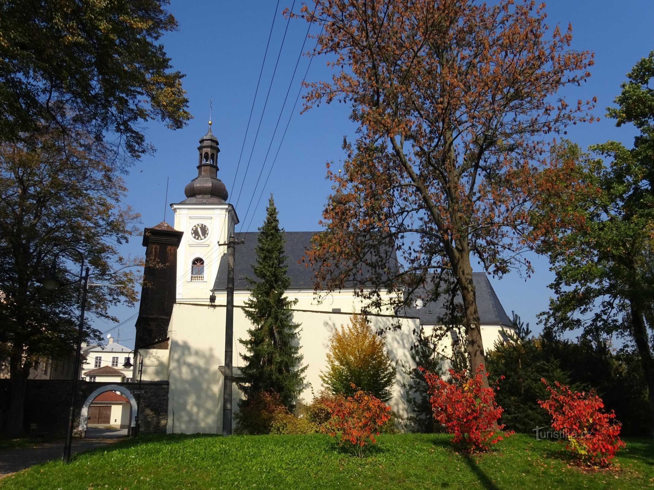 pohled na kostel z parku, vlevo branka v opevnění