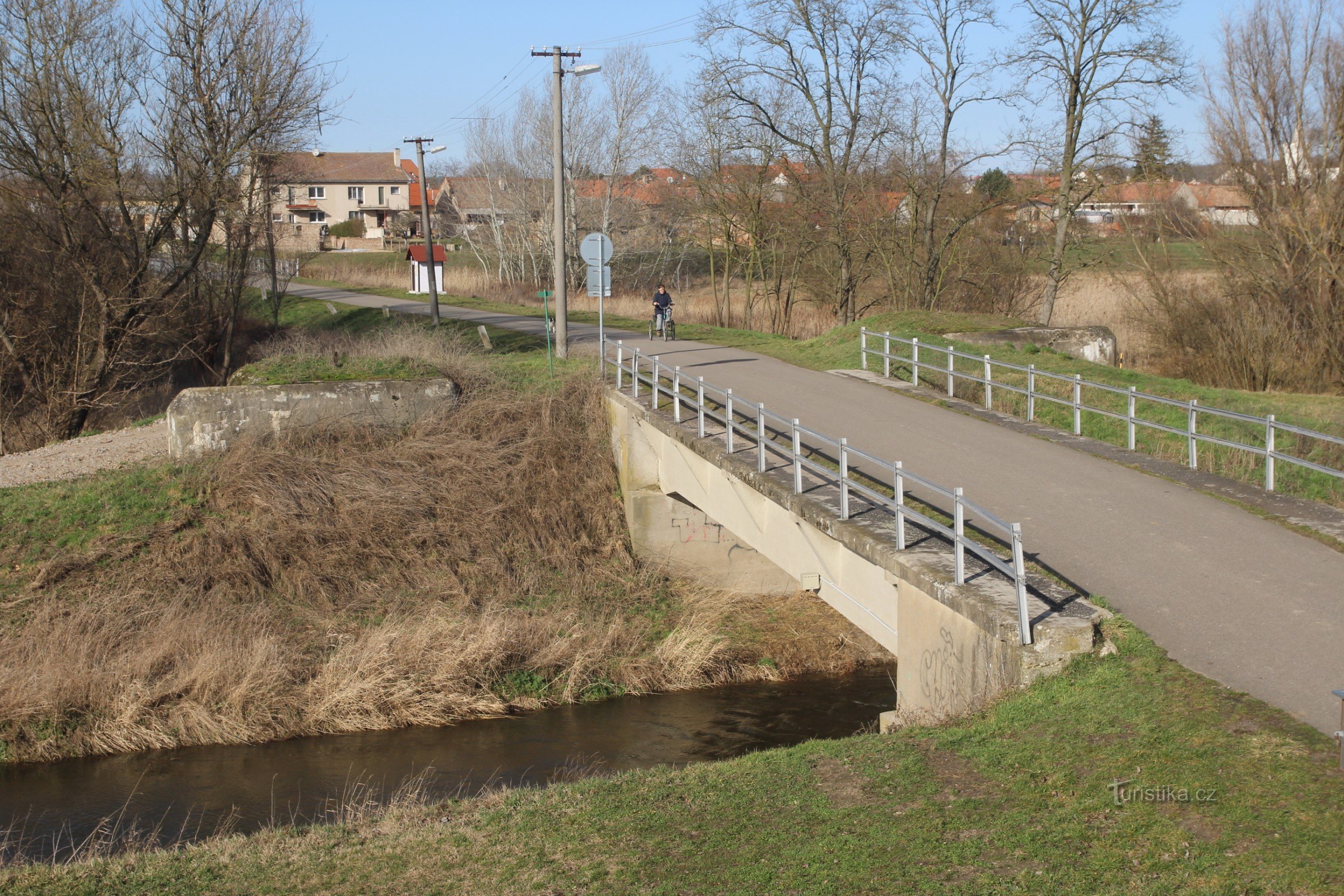 Vista da ponte sobre o rio Jevišovka com duas palafitas