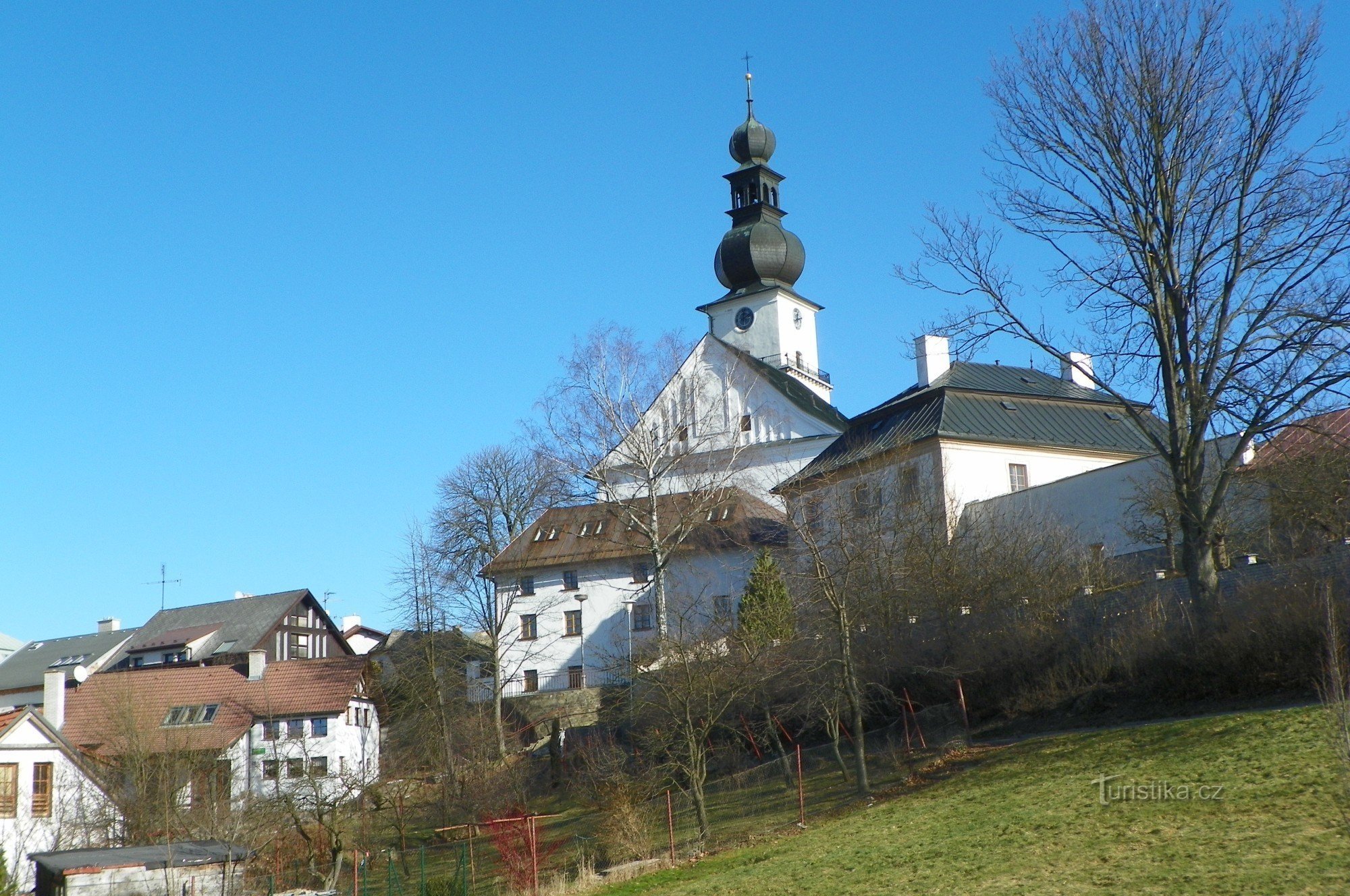 Pogled na Moučkovo hišo, župnišče in cerkev sv. Prokop Farské Humen