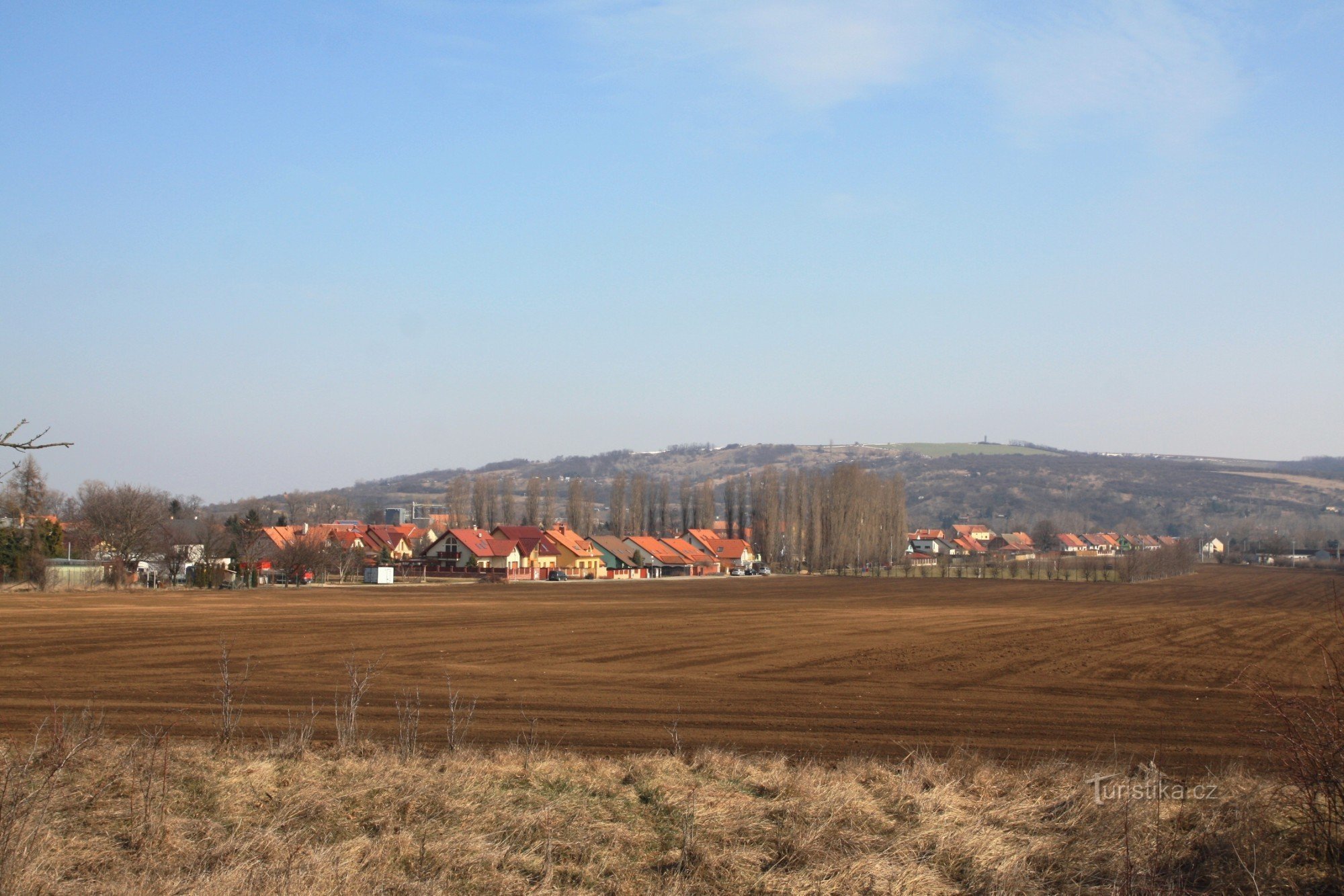 Pohled na Vojkovice od železniční trati, v pozadí kopec Výhon