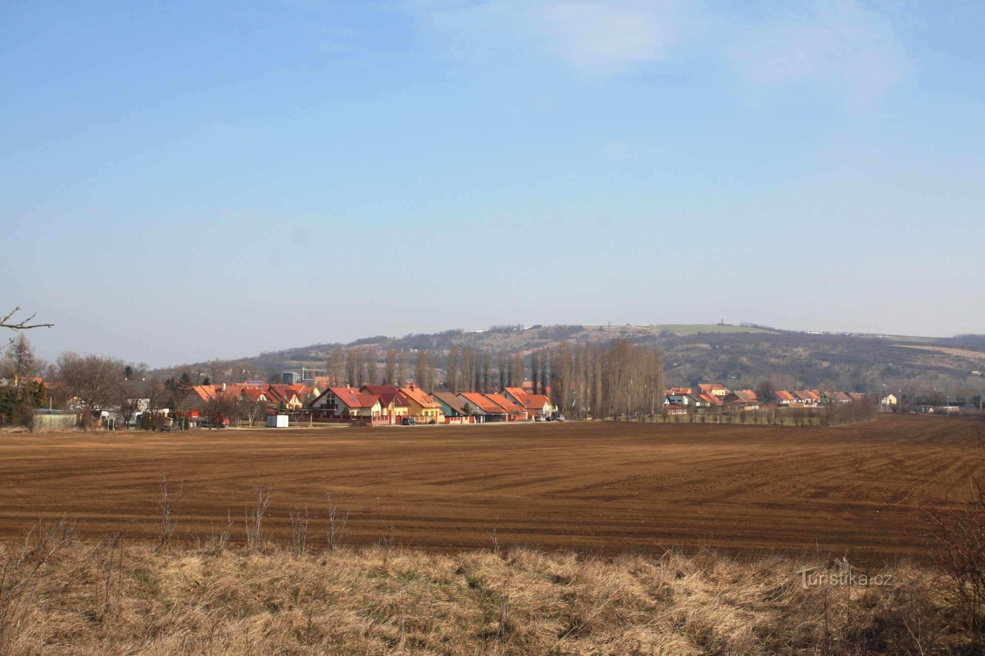 Vedere la Vojkovice de pe linia de cale ferată, dealul Výhon în fundal