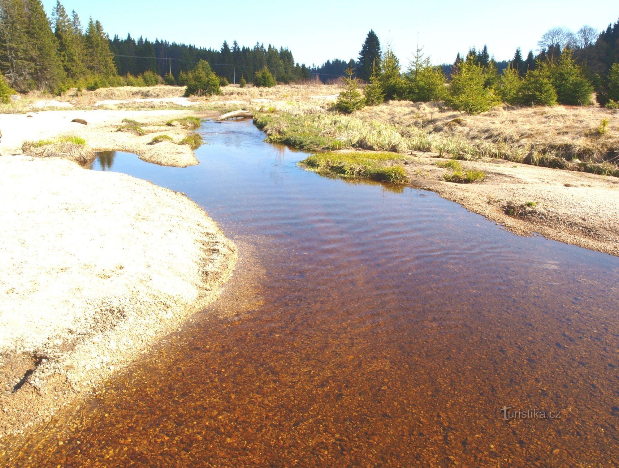 Ein Bergbach direkt über der Mündung des Stausees. Das Wasser hat eine Moorfarbe