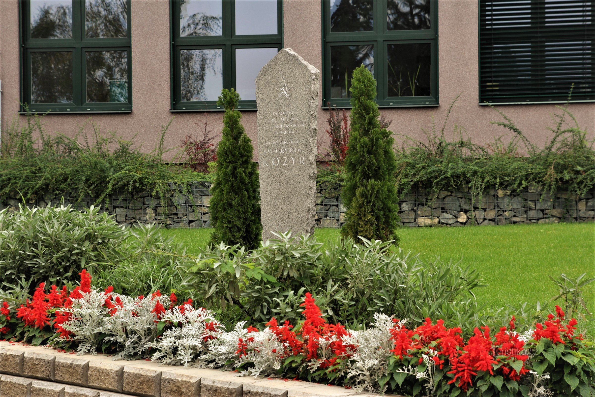 Monument til general Kozyr foran bygningen af ​​Secondary School of Horticulture