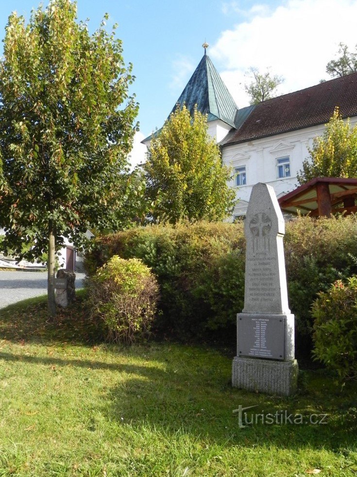 Monument to the fallen in the background of the castle