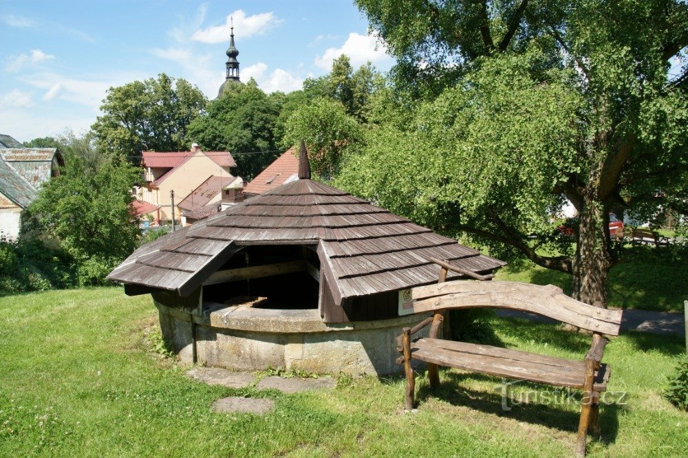 sentado junto à fonte de pedra Na Měšeček