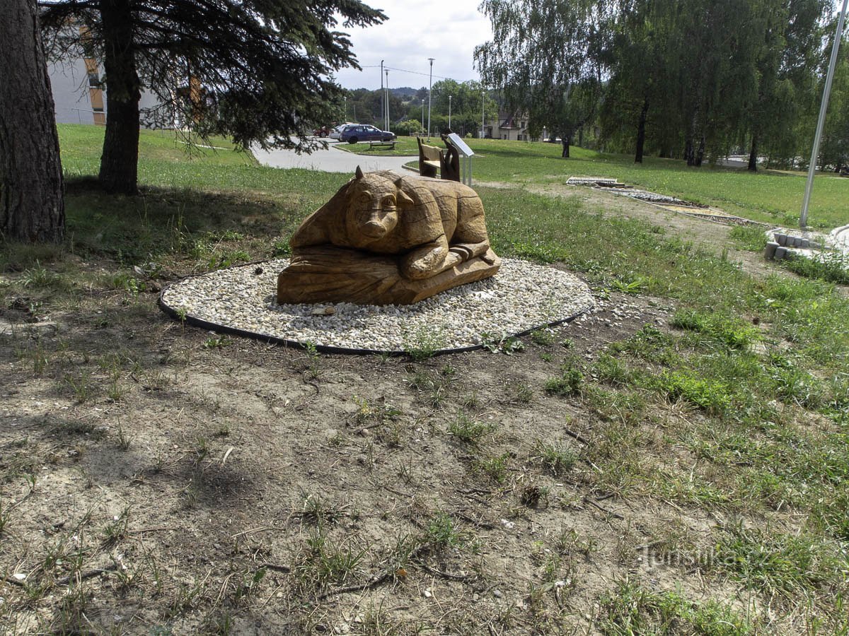 Vor dem Bürgersteig steht eine Skulptur