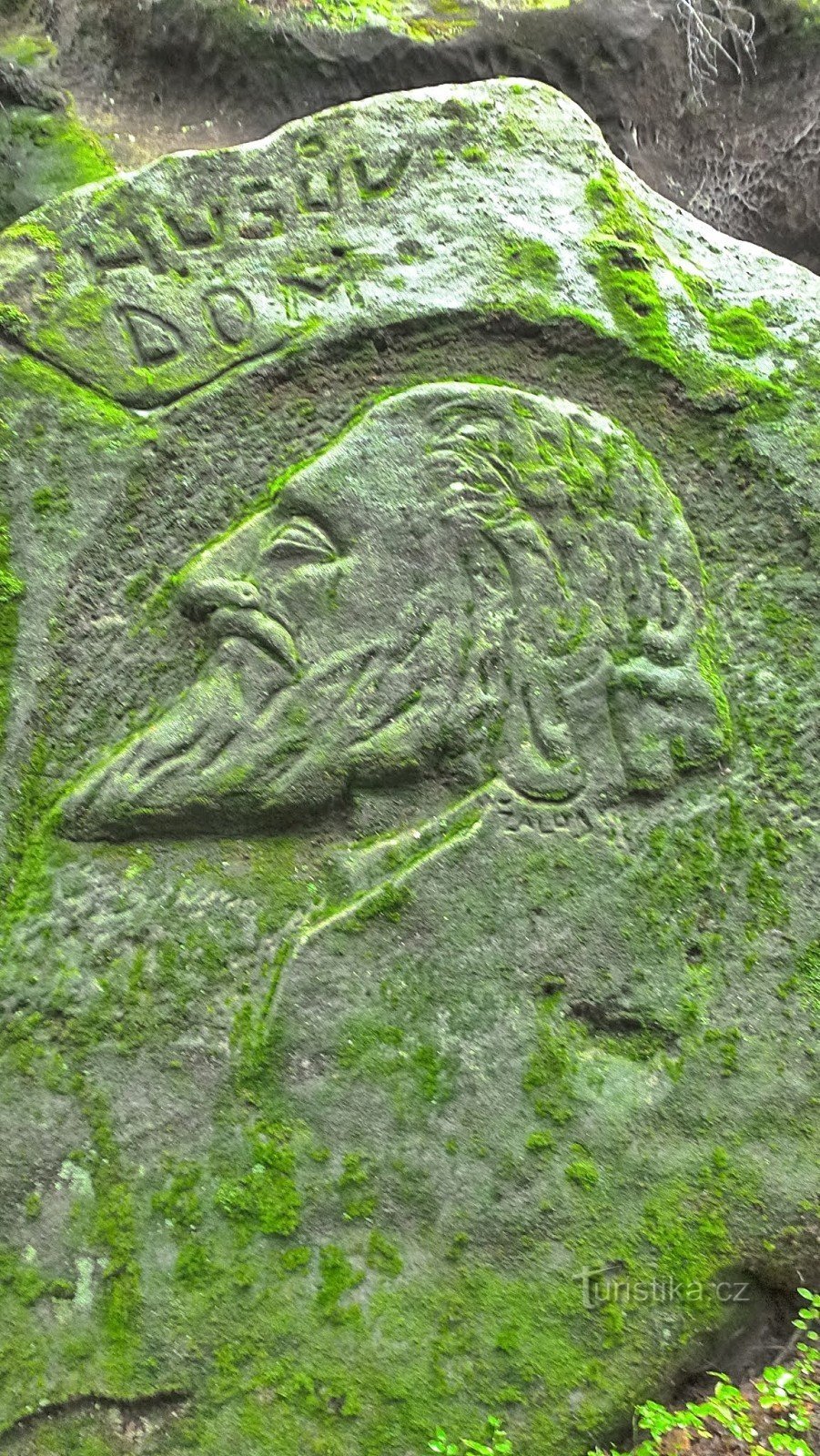 trước cửa hang, bức chân dung của Jan Hus được khắc vào khối đá