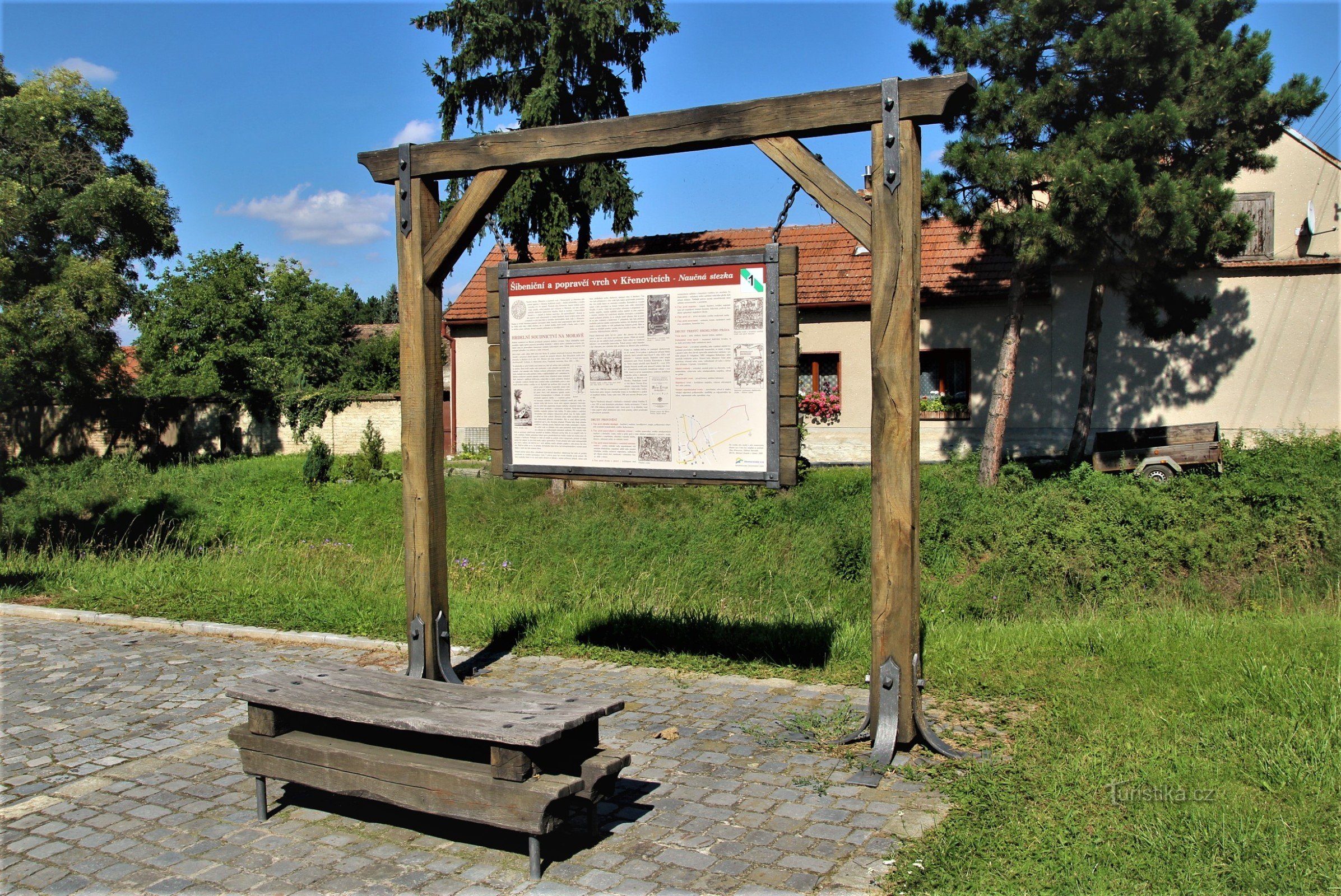 První zastávka naučné stezky je u mostu na hlavní ulici, kudy prochází zeleně zn