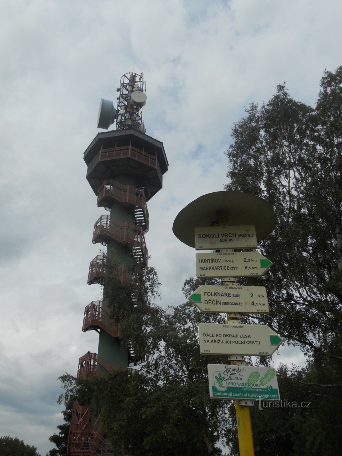 Uma placa de sinalização ao fundo com uma torre de vigia.