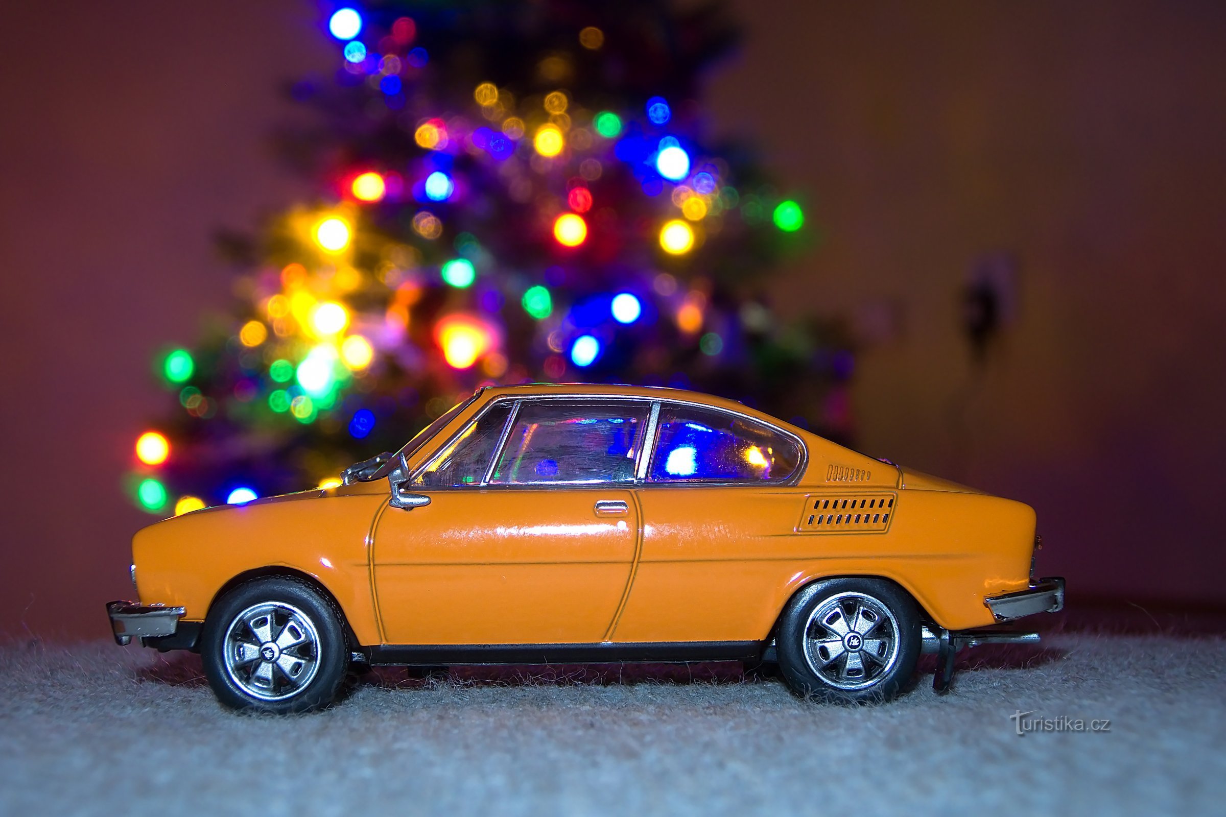 Škoda 110R sur un tabouret près du sapin de Noël.