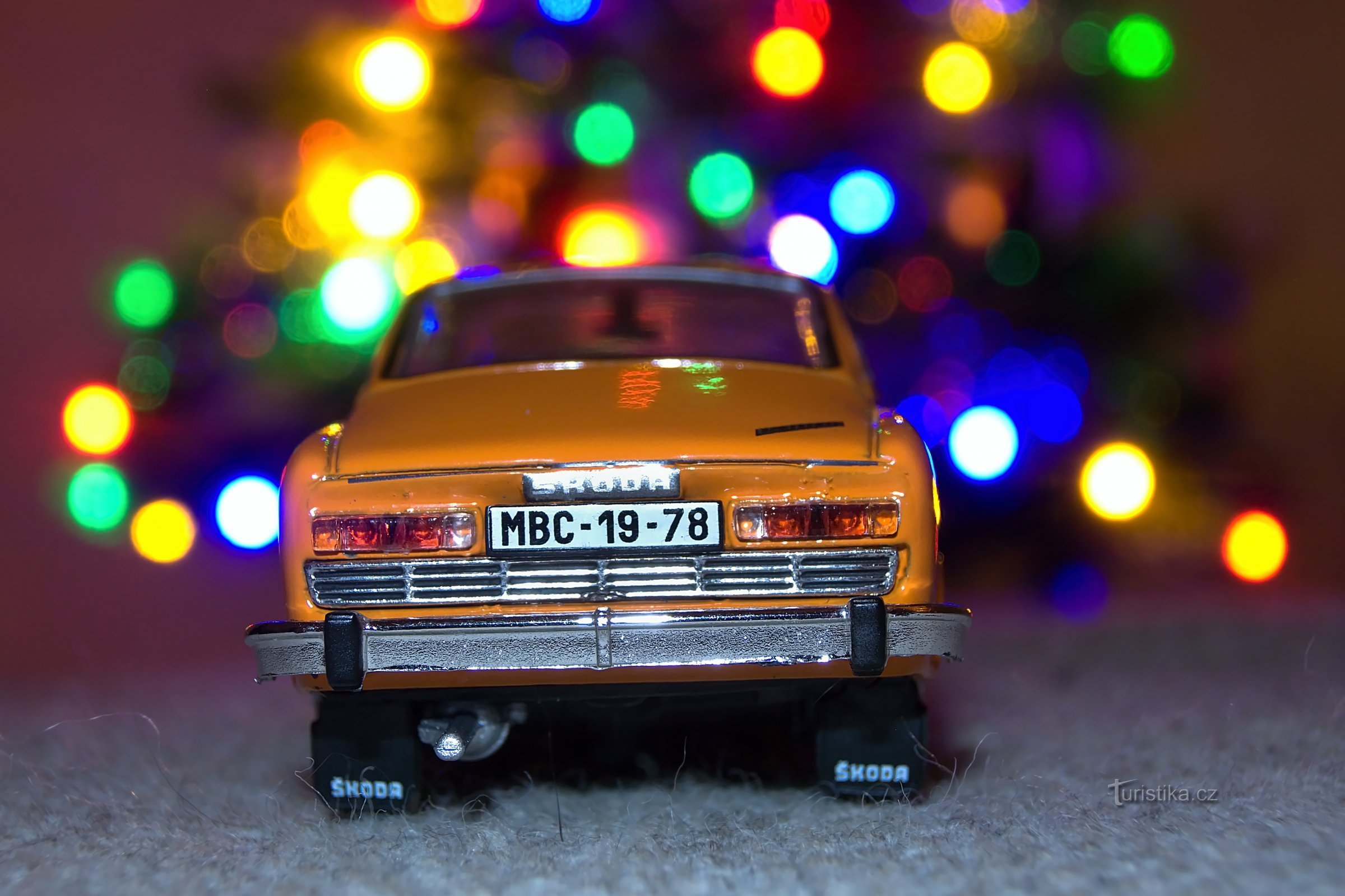 Škoda 110R sur un tabouret près du sapin de Noël.