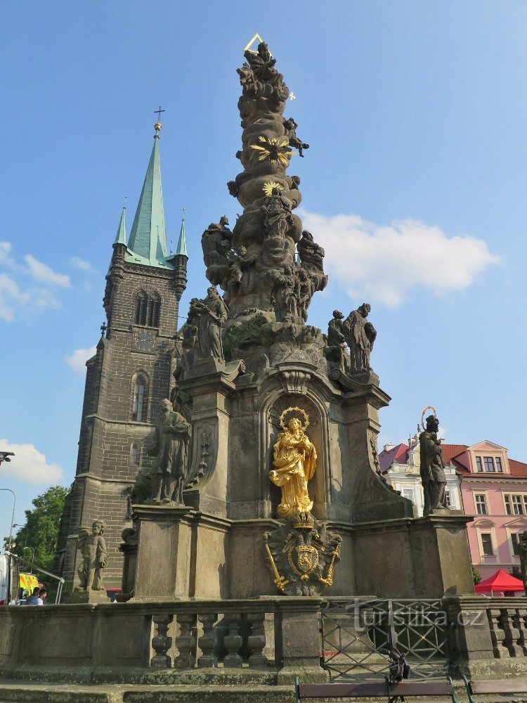 a column with a fountain in front of the NPM temple