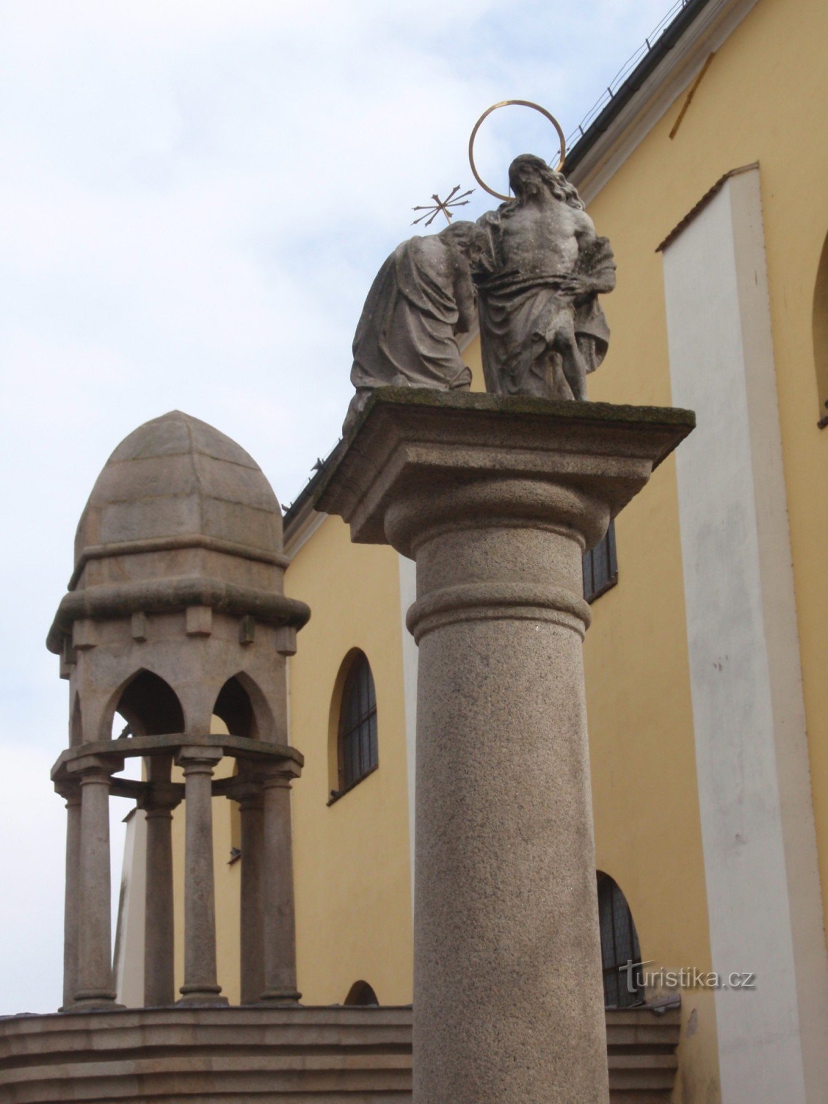 A column with a sculpture of Christ's Baptism in Havlíčková Brod