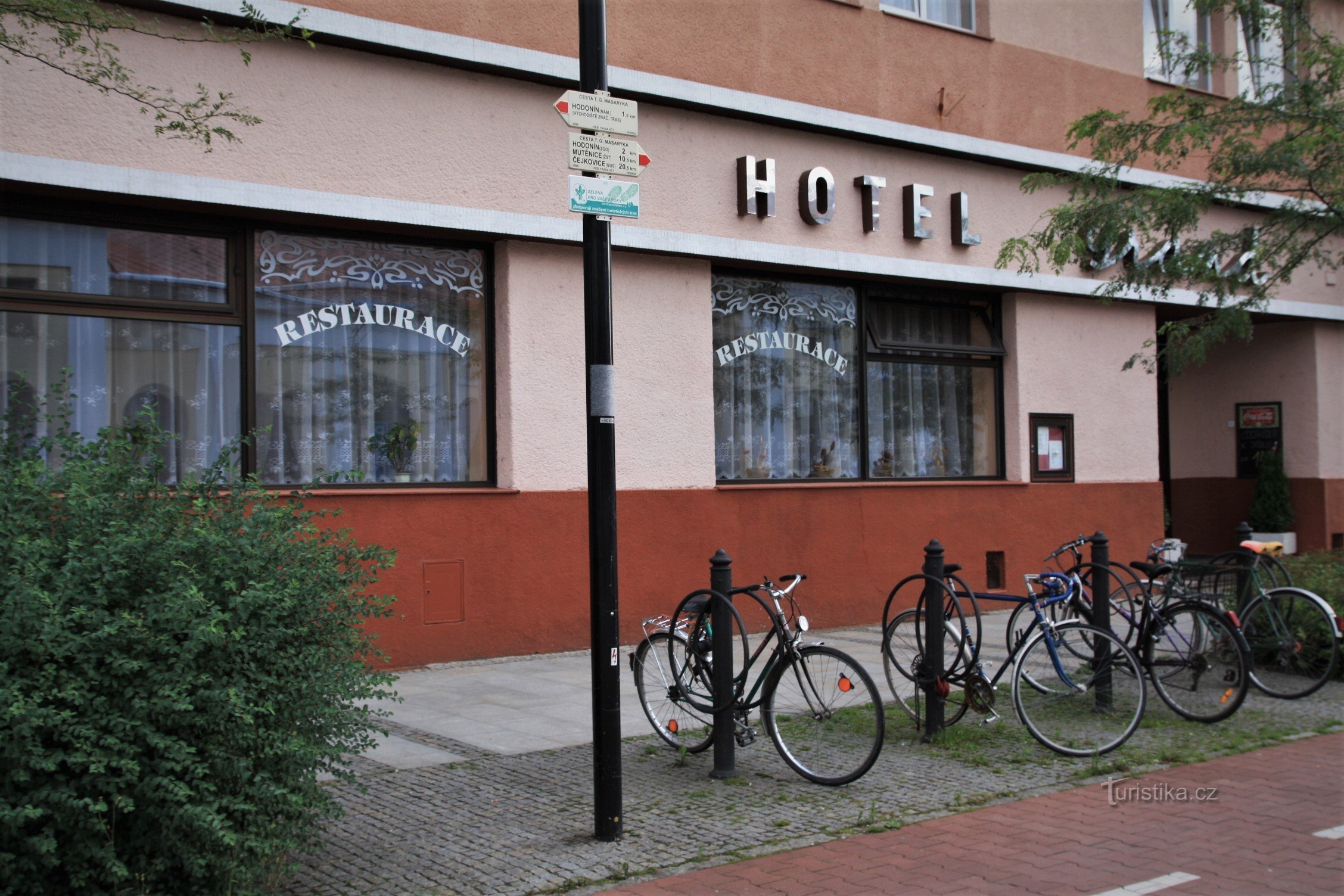 Des panneaux directionnels sont montés sur un lampadaire public devant le Grand Hôtel, en face