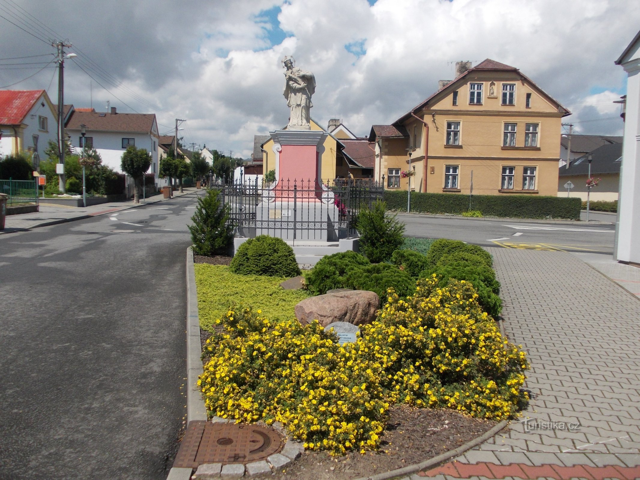 posąg i zabłąkany głaz w małym parku