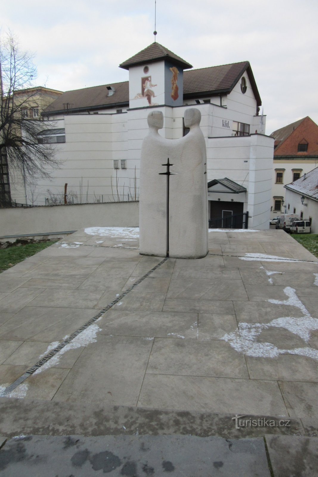 The Thessalonica brothers on a plinth with an inset cross, in the background the Goose on a String theater