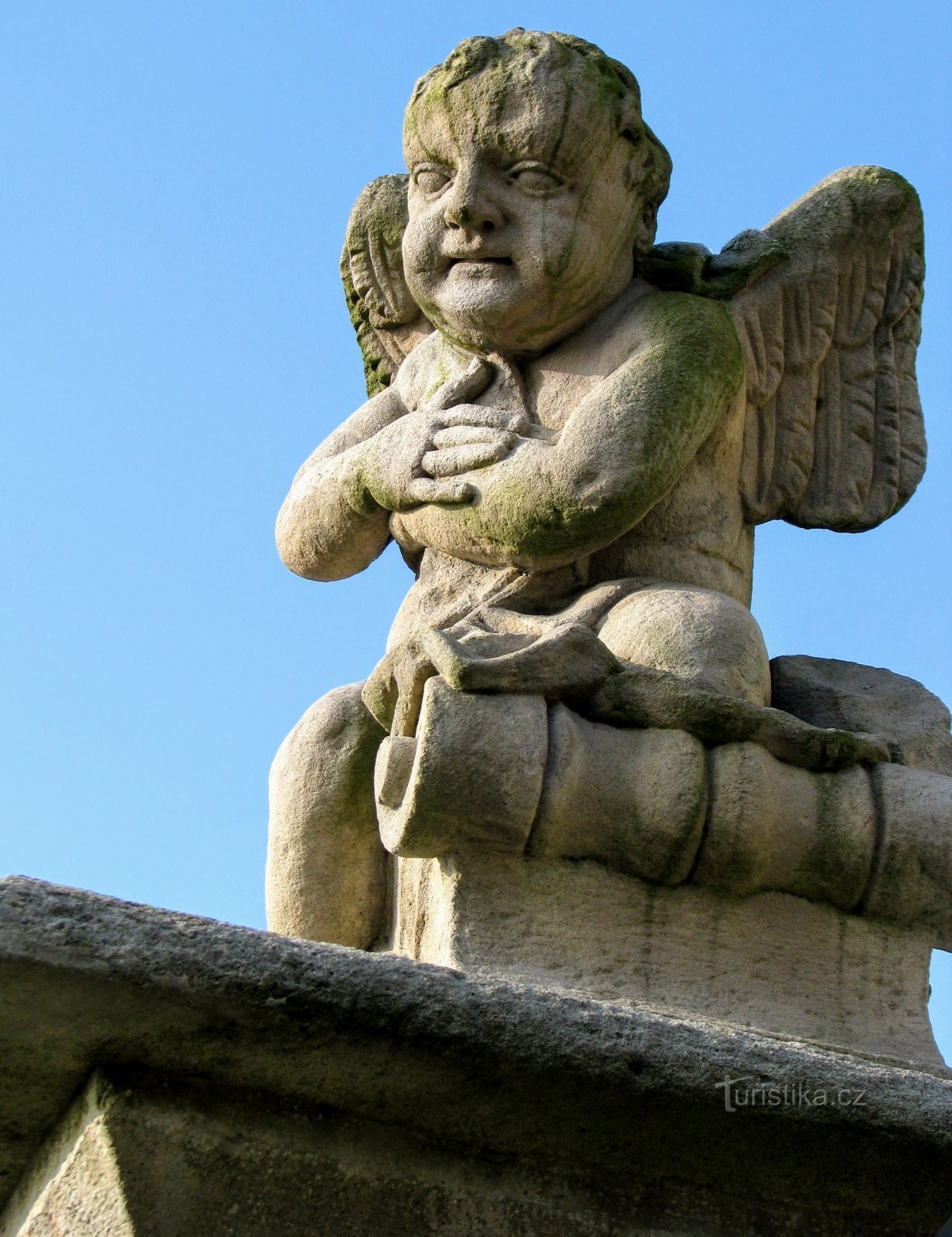 Soška barokního anděla při kostelní bráně