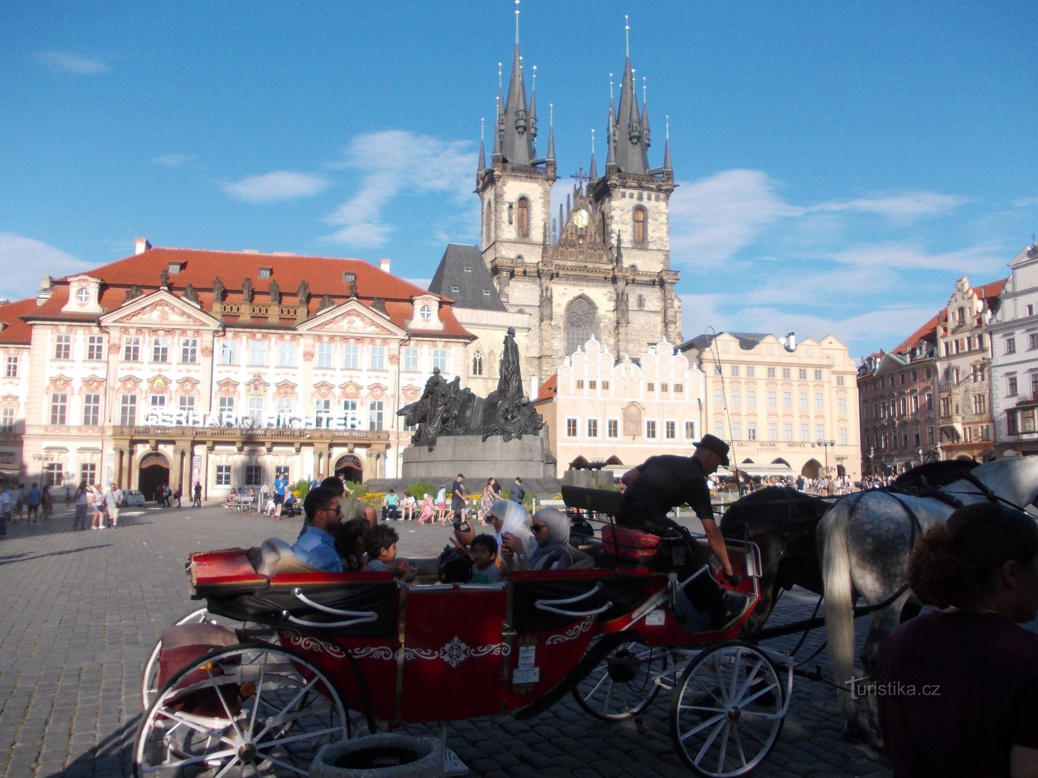 Staromestské námestie s kočom, palácom Kinských a Týnskym chrámom