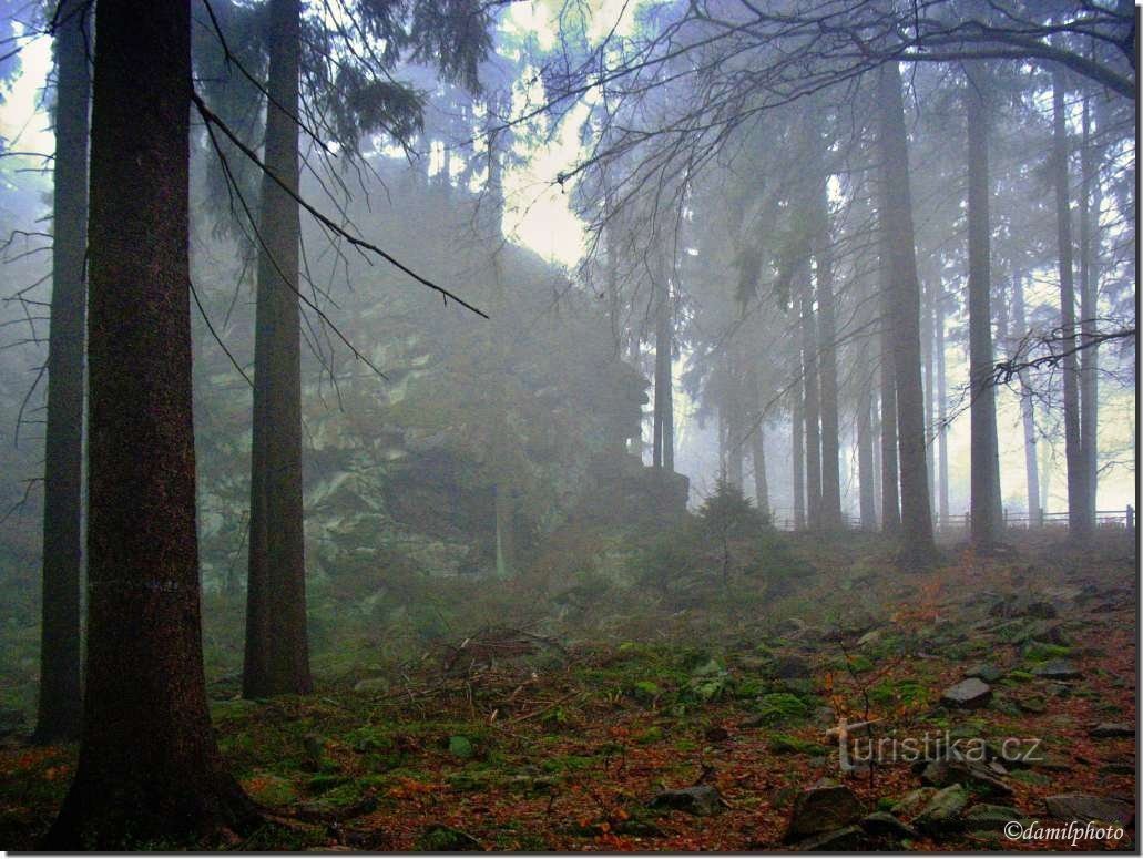 Zimne poranne mgły po całonocnym deszczu pokrywają szczytową skałę Bohdalka