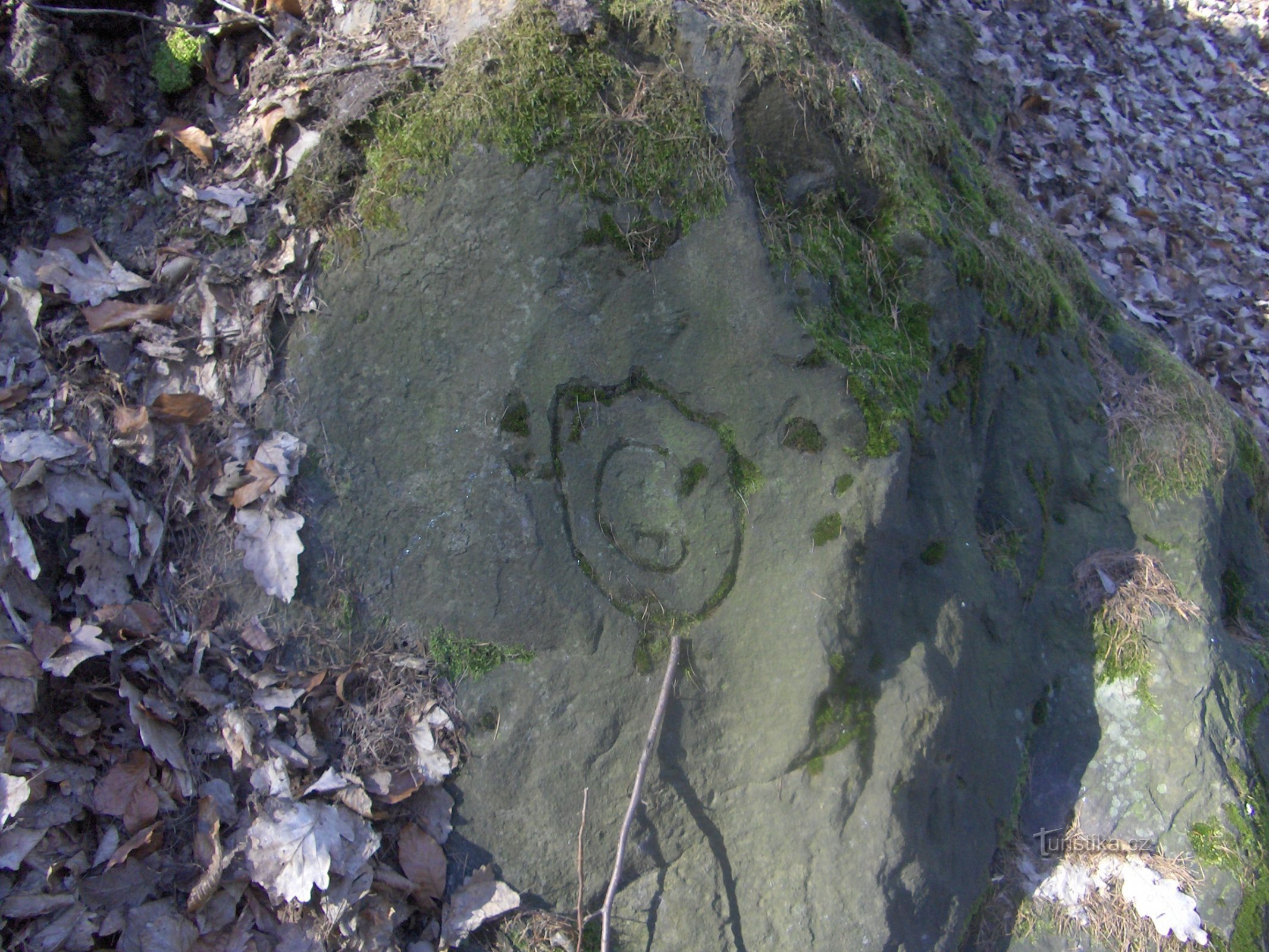 Visages mystérieux et inscriptions sur le rocher.