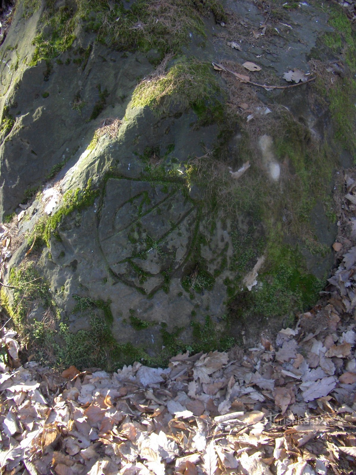 Visages mystérieux et inscriptions sur le rocher.