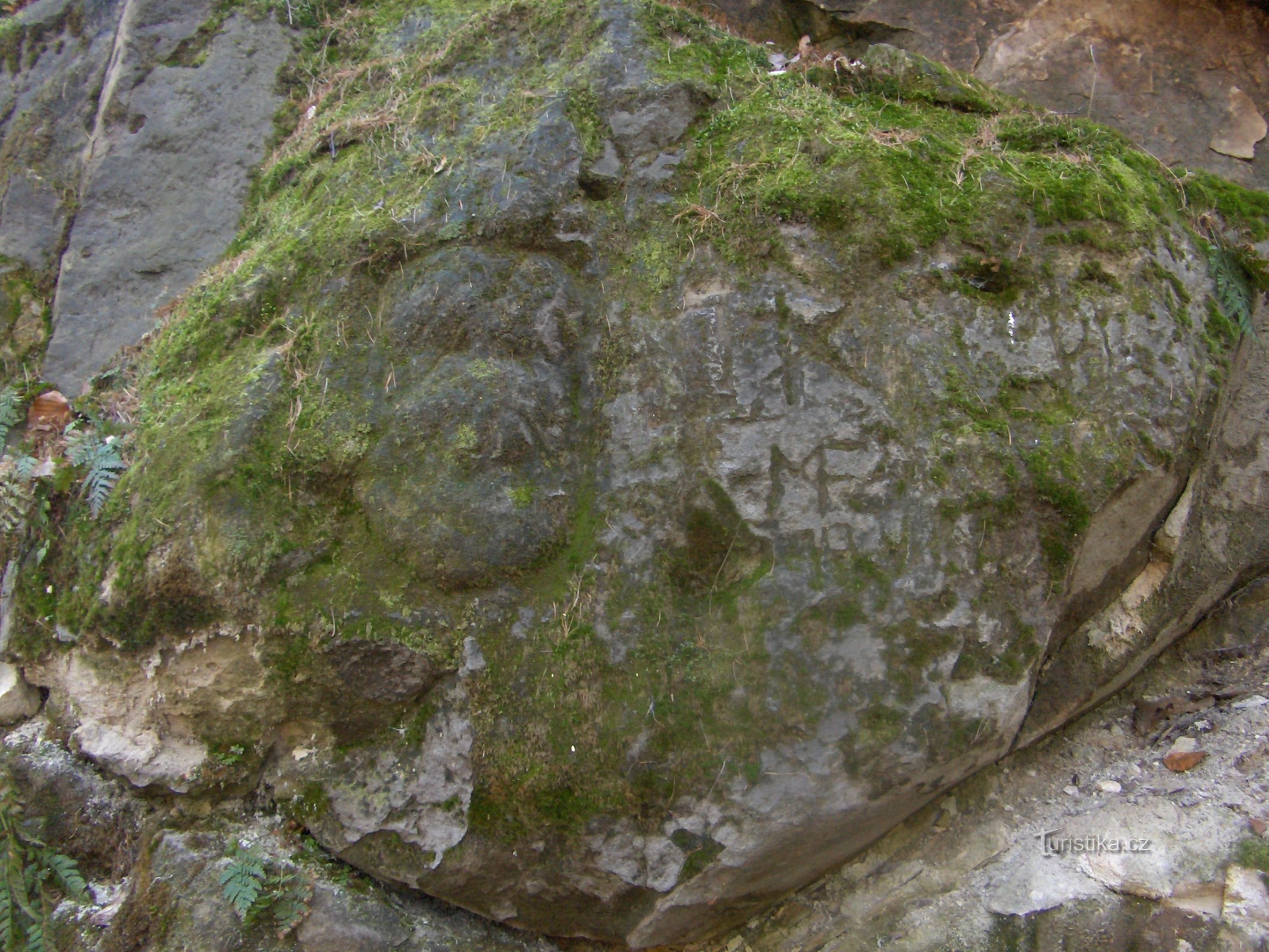 Geheimnisvolle Gesichter und Inschriften auf dem Felsen.