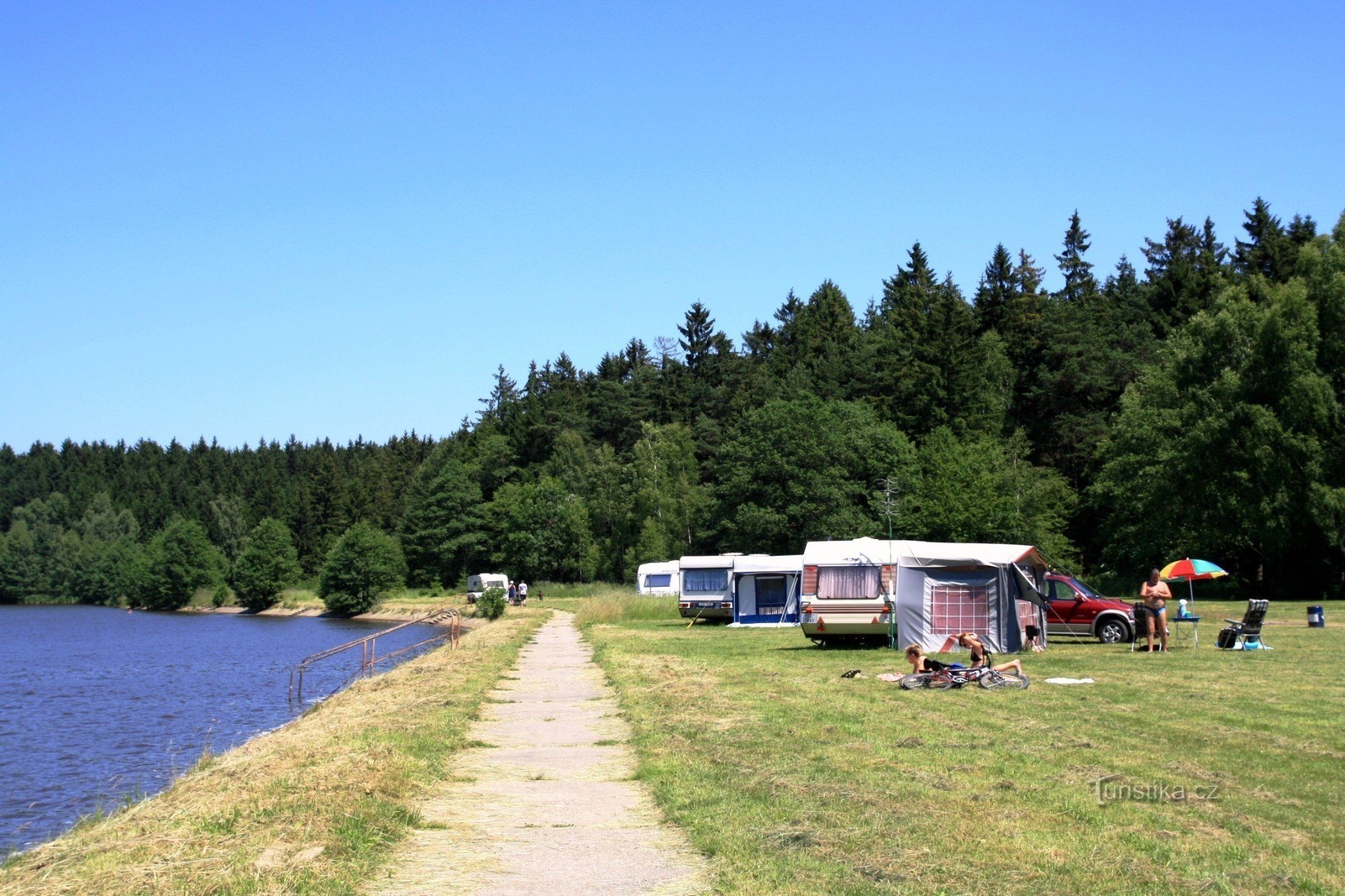 The grassy area of ​​the car park on the shore of the pond