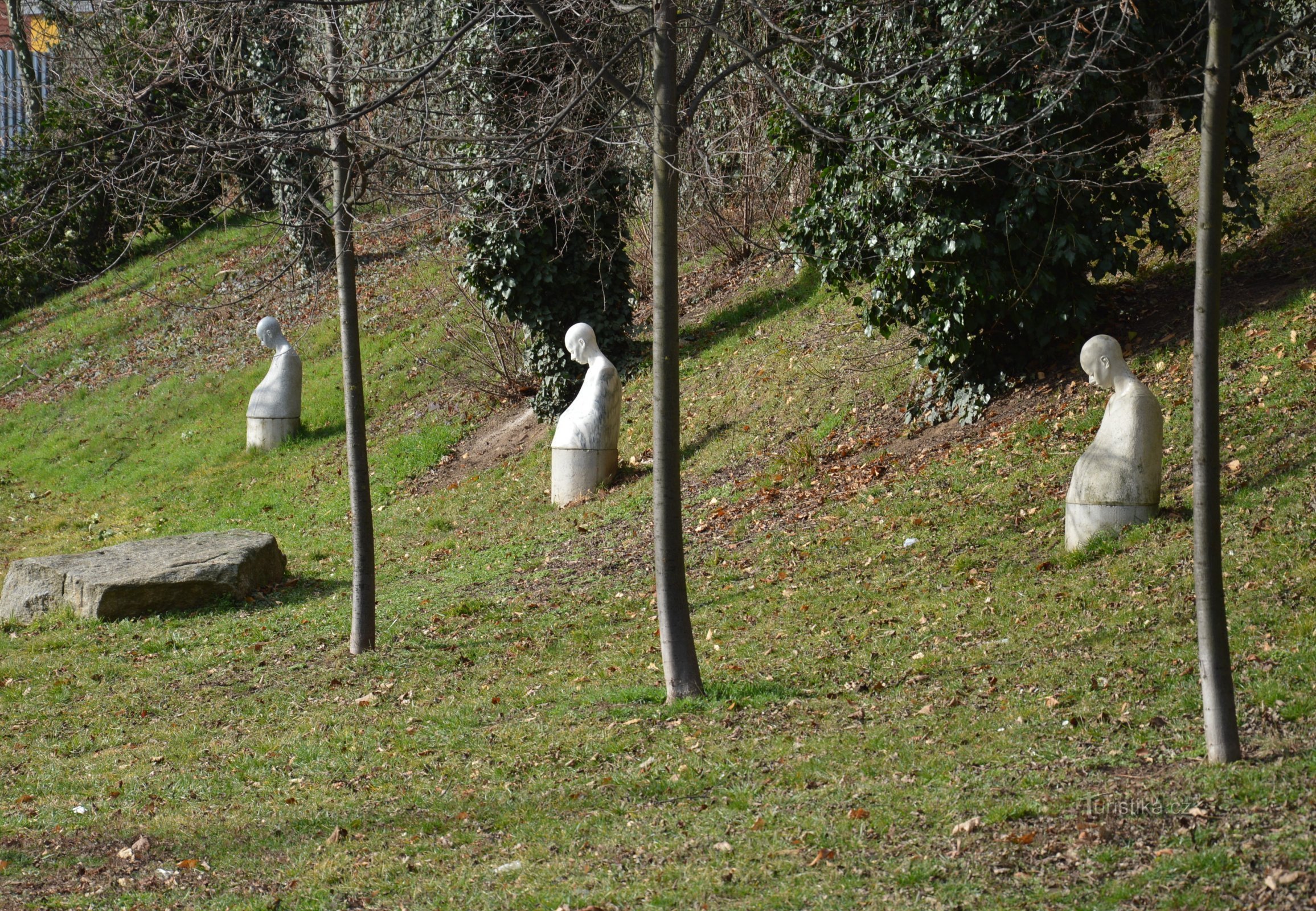 Trei statui Madone în fața zidului cimitirului