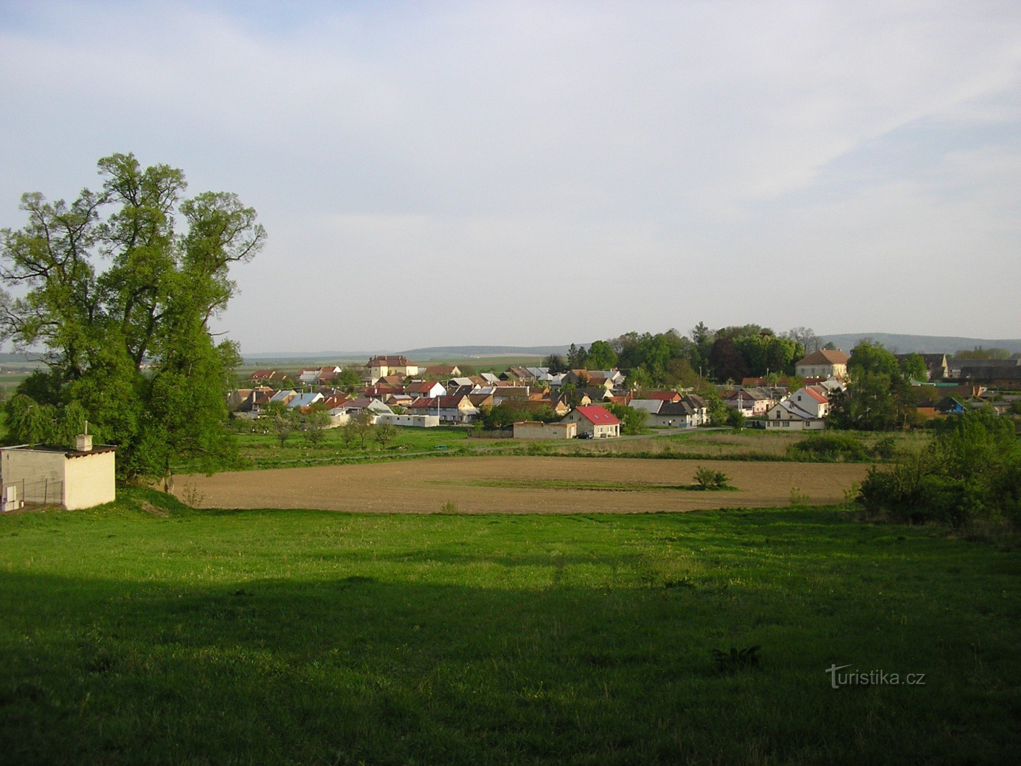 Uhrice. In the foreground is a memorial linden tree, the higher building in the middle is the former school and the building in