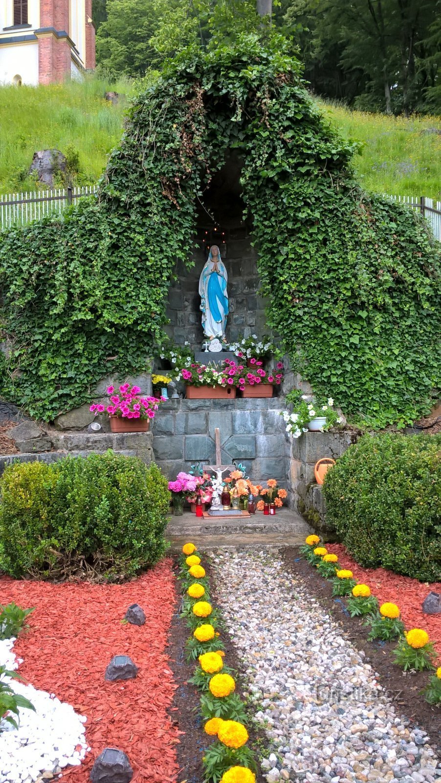 una cueva artificial con la Virgen María de Lourdes en el manantial