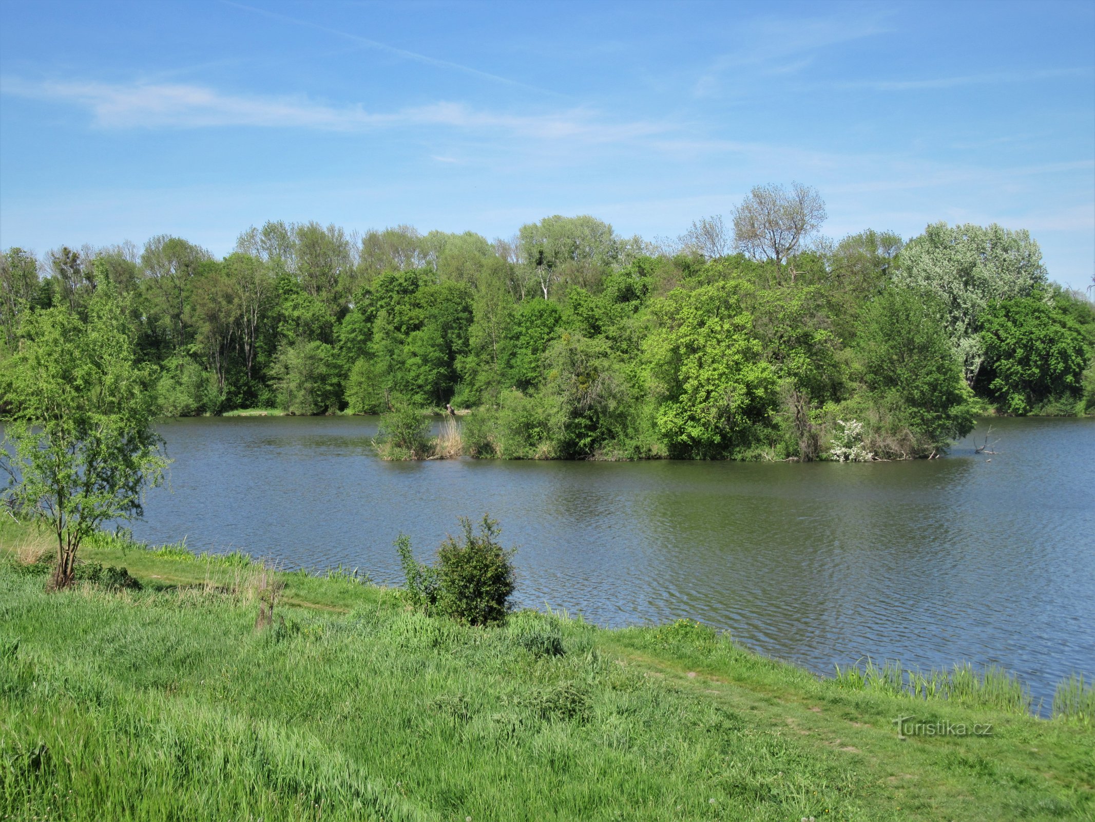 There is an island in the middle of the pool of water and a bunker is hidden in its greenery