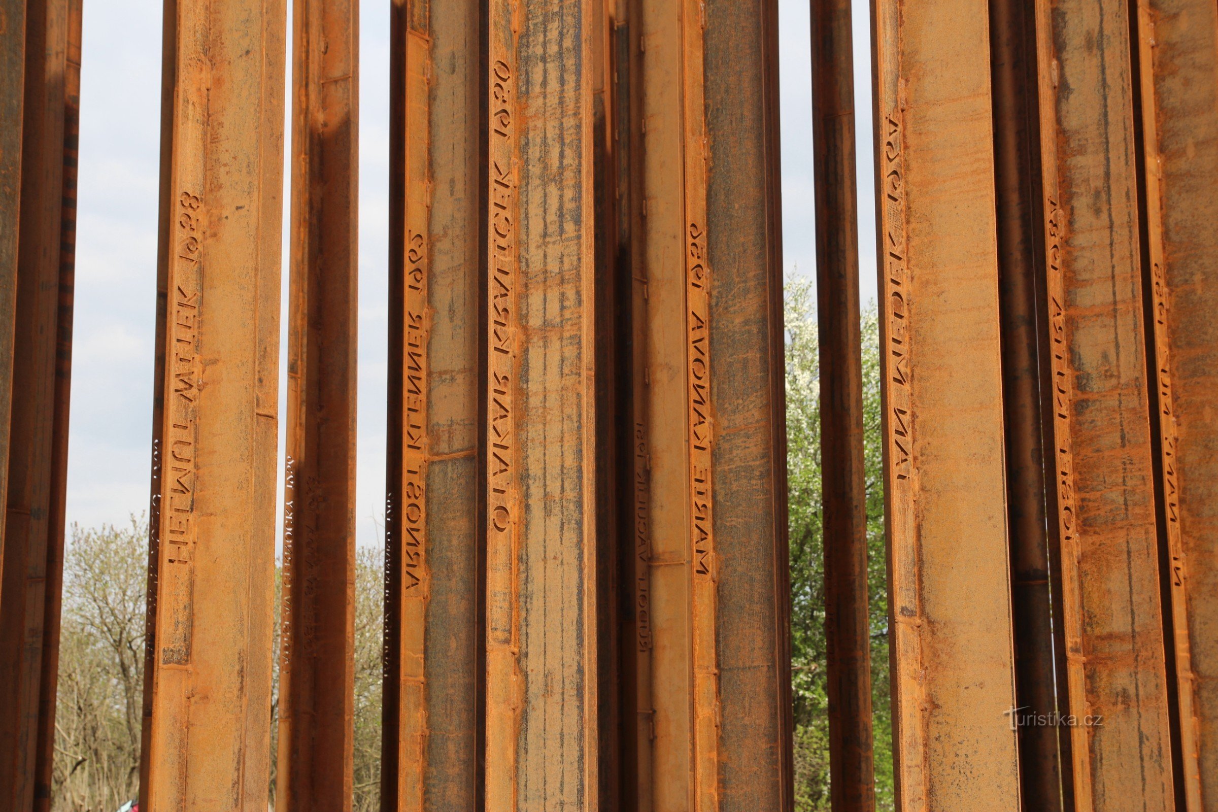 На металлической стеле выбито имя жертвы и год смерти.