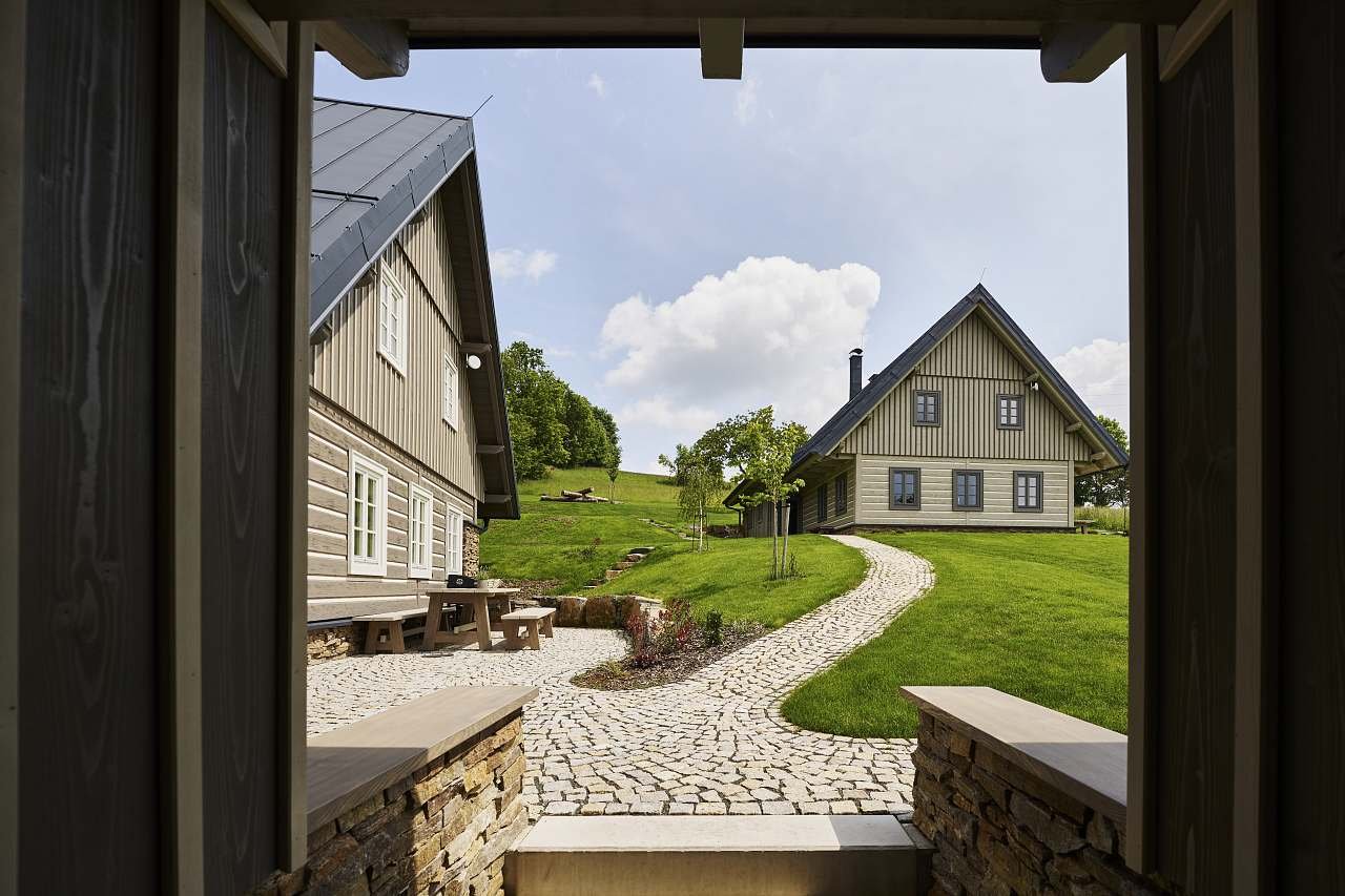 Vchod do areálu a terasa chalupy Raz