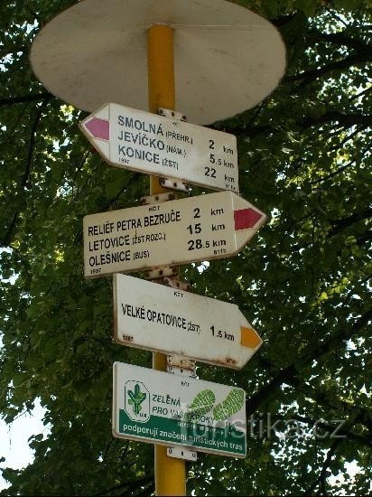 Velké Opatovice - signpost: Red and yellow tourist signpost near the castle.