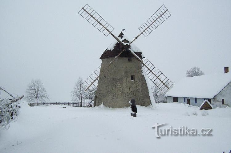 Mlin na veter pri Kuželovem: januar 2006, pred mlinom spominsko obeležje rudarskemu godcu.