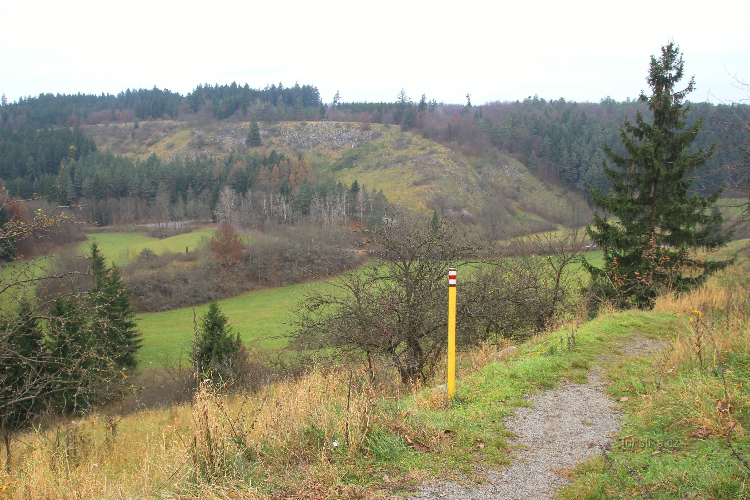 Un traseu de drumeții marcat cu roșu traversează pârtia Vilémovická, o vedere a omologului