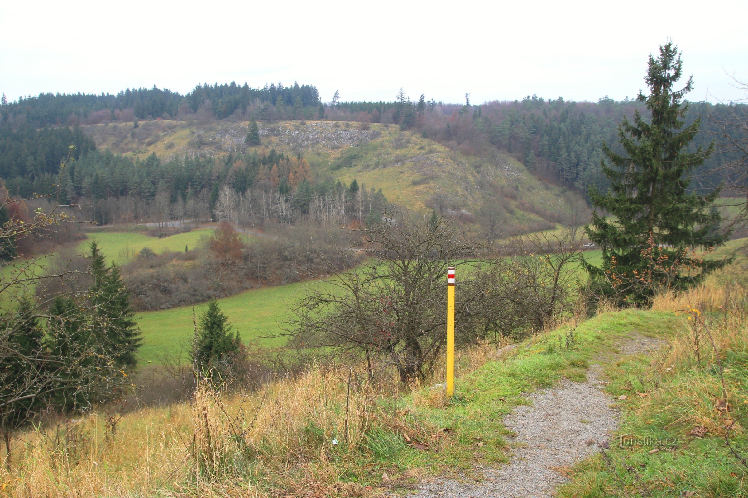 Een rood gemarkeerd wandelpad kruist de Vilémovická-helling, uitzicht op de tegenhanger